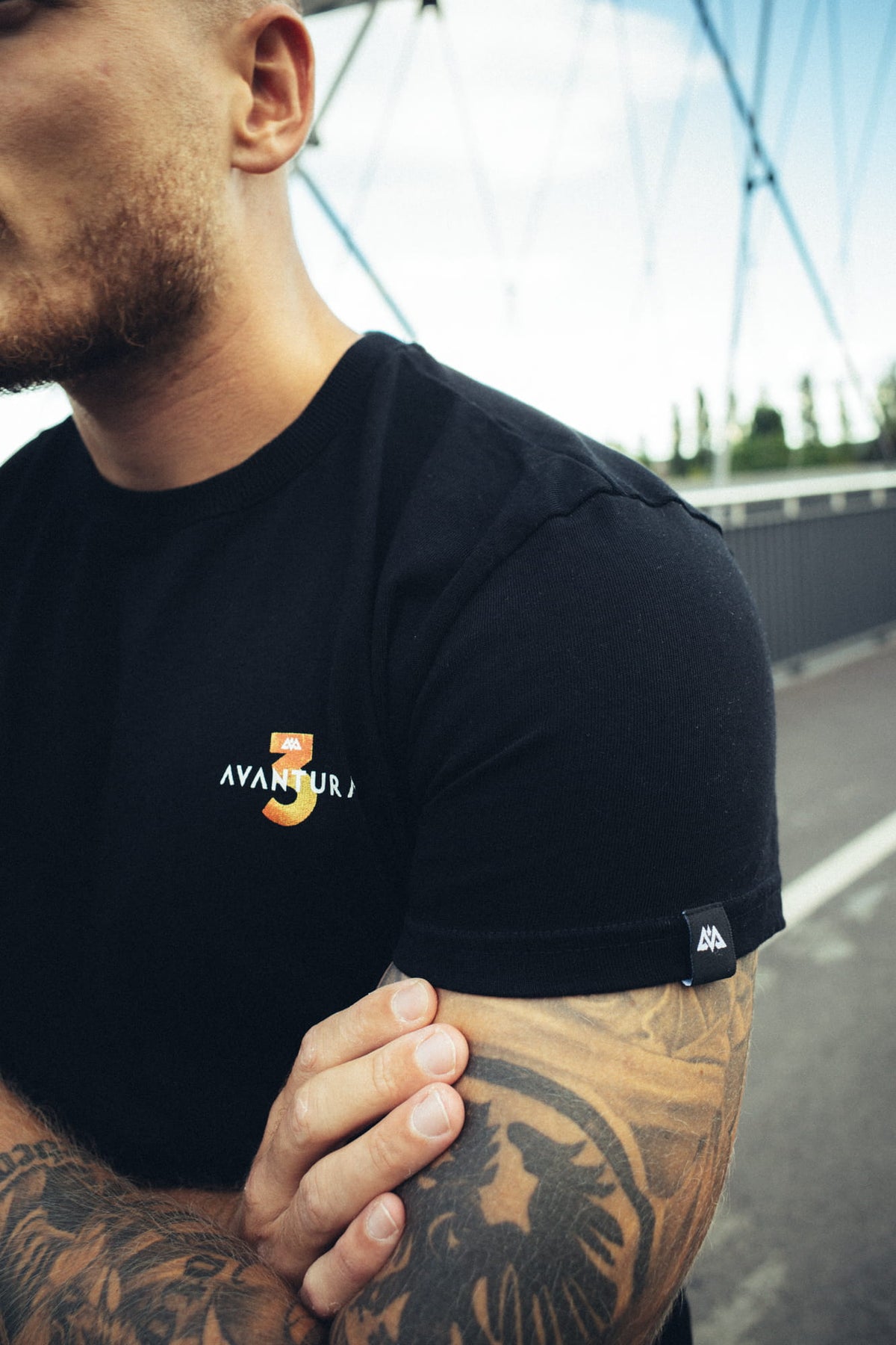 Nahaufnahme des kleinen Brustlogos am schwarzen T-Shirt