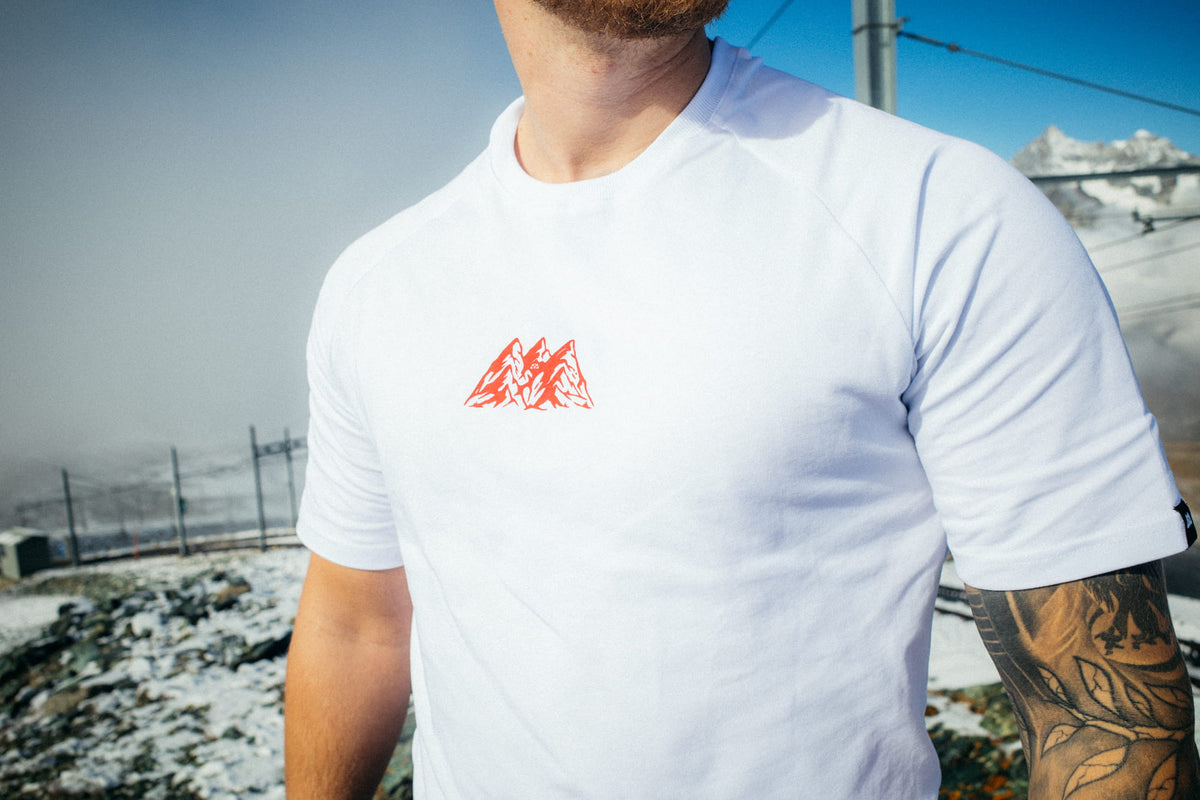Close-up white T-shirt with small red logo mountain print on chest