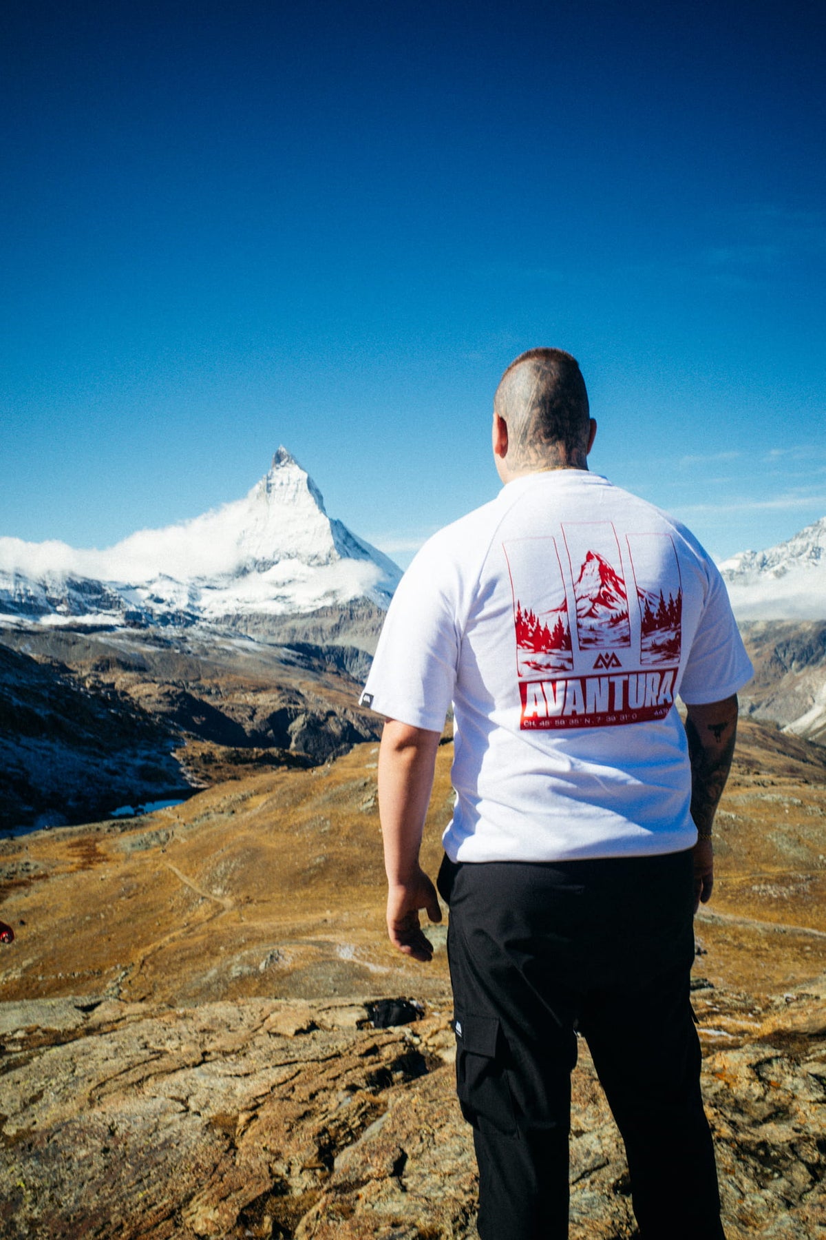 White T-shirt with large red back print worn in alpine setting