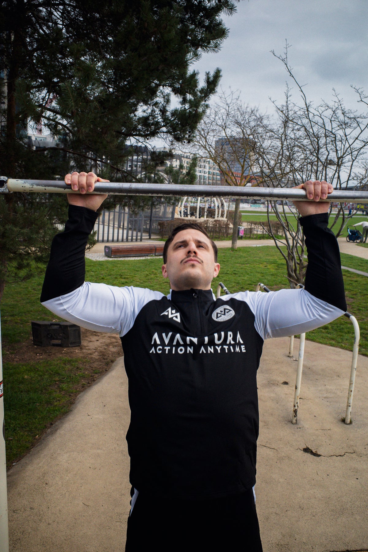 Schwarzer Halfzip-Sweater mit weißen Schultern und zentriertem Logo beim Klettern