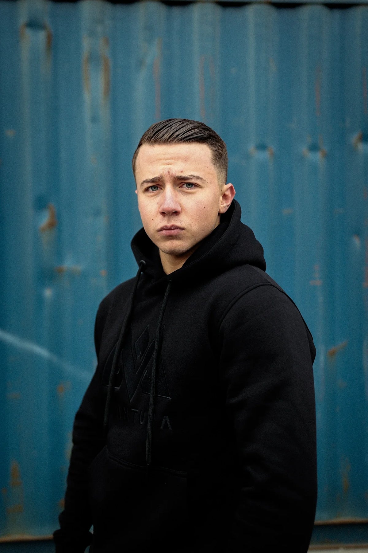 Seitenansicht schwarzer AVANTURA Hoodie mit Brustlogo und optimaler Passform