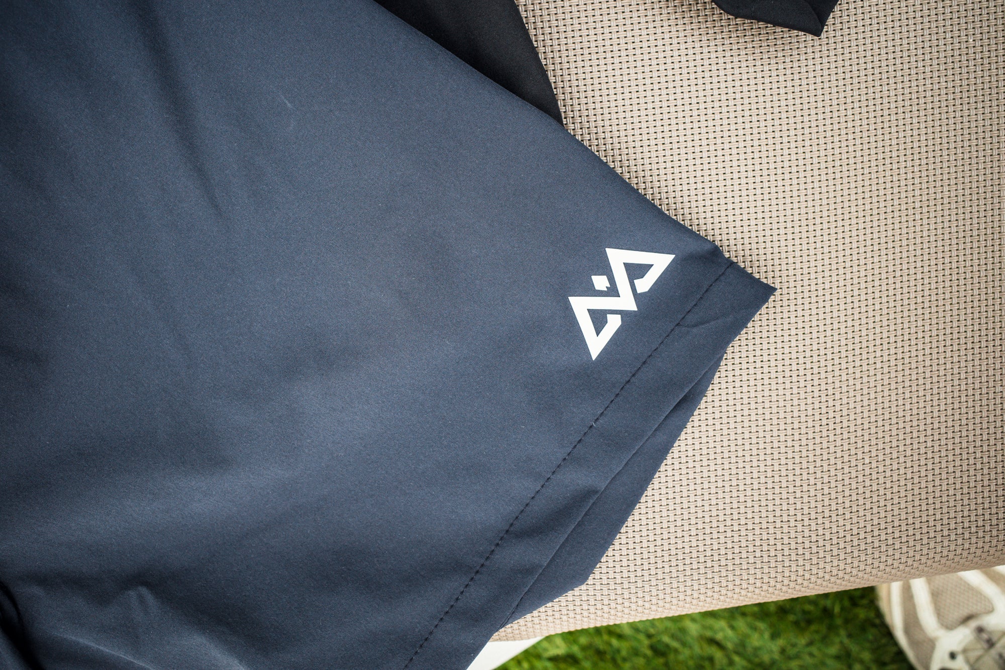 Close-up of white geometric logo on swim trunks