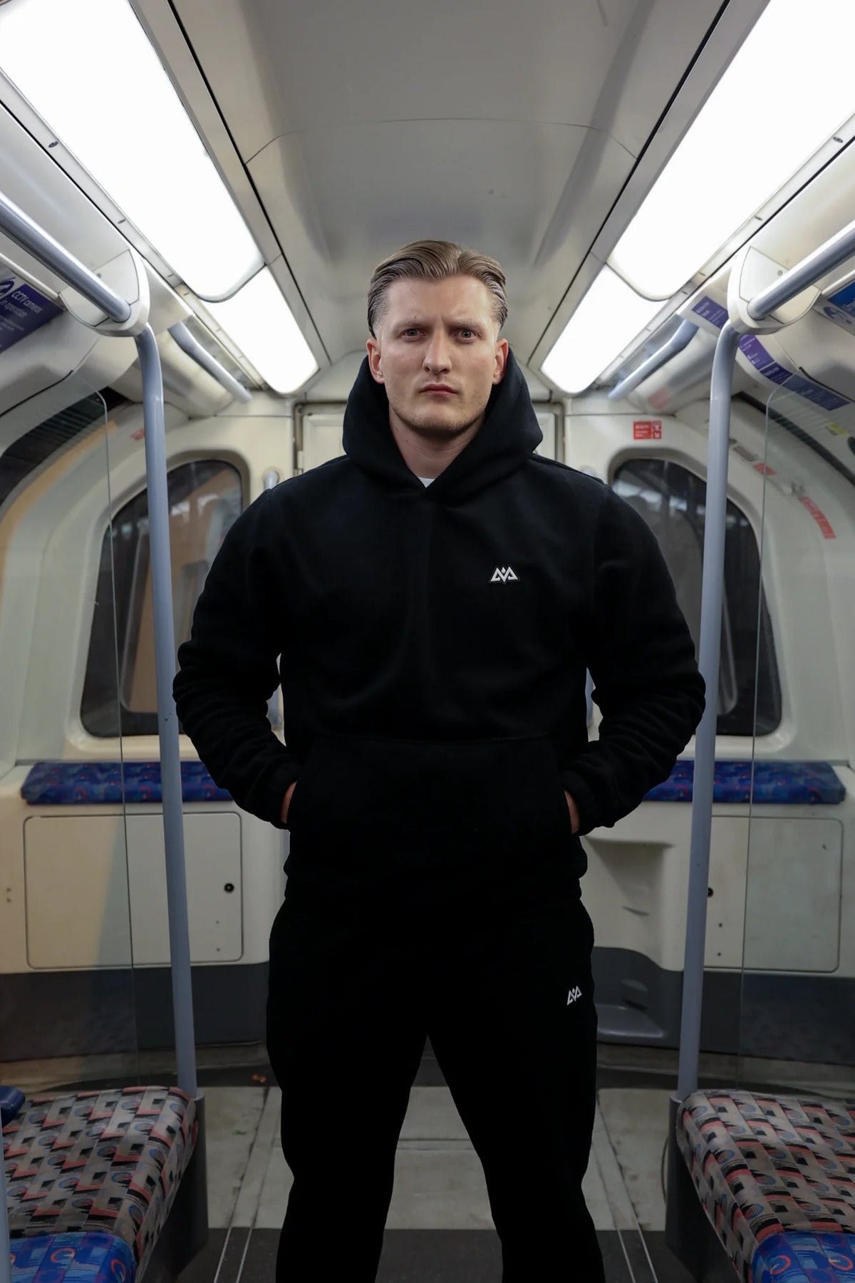 Front view of black fleece hoodie with kangaroo pocket and small white chest logo