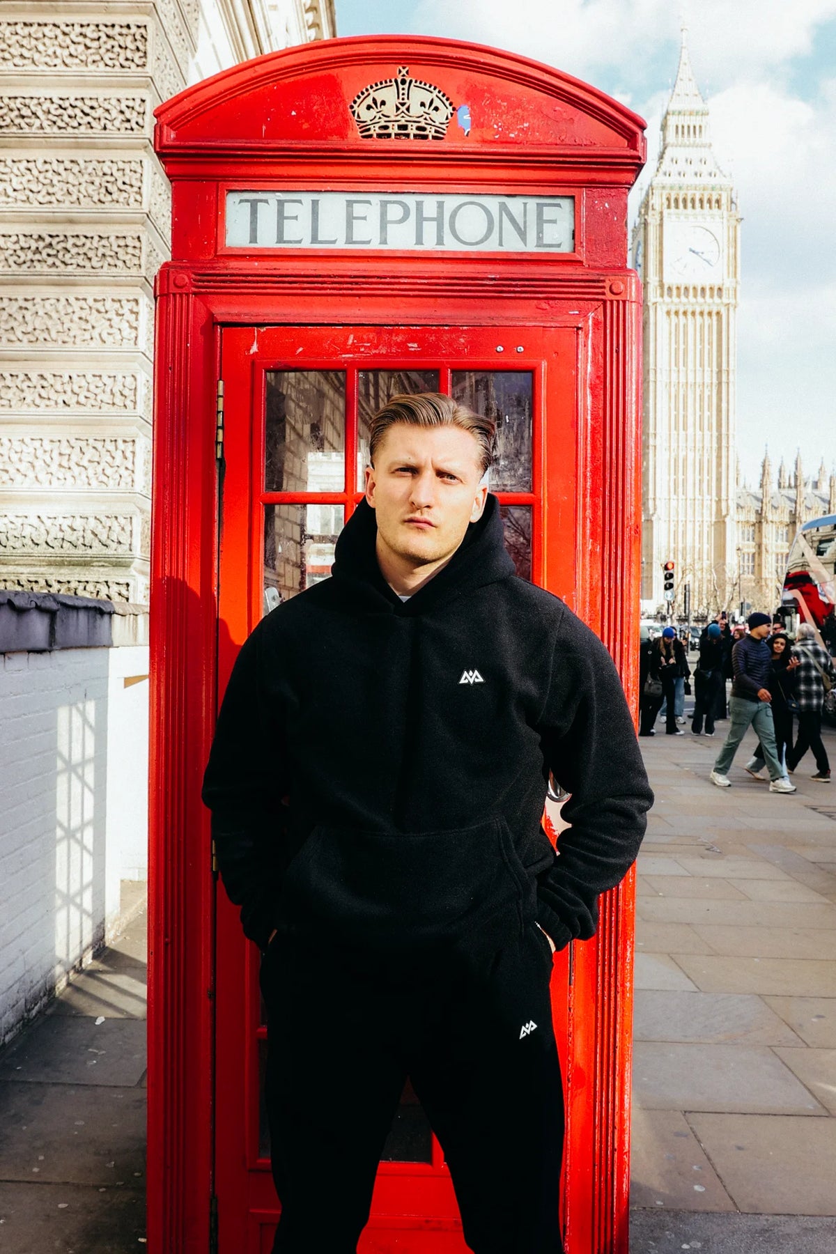 Man wearing black fleece joggers and hoodie near Big Ben