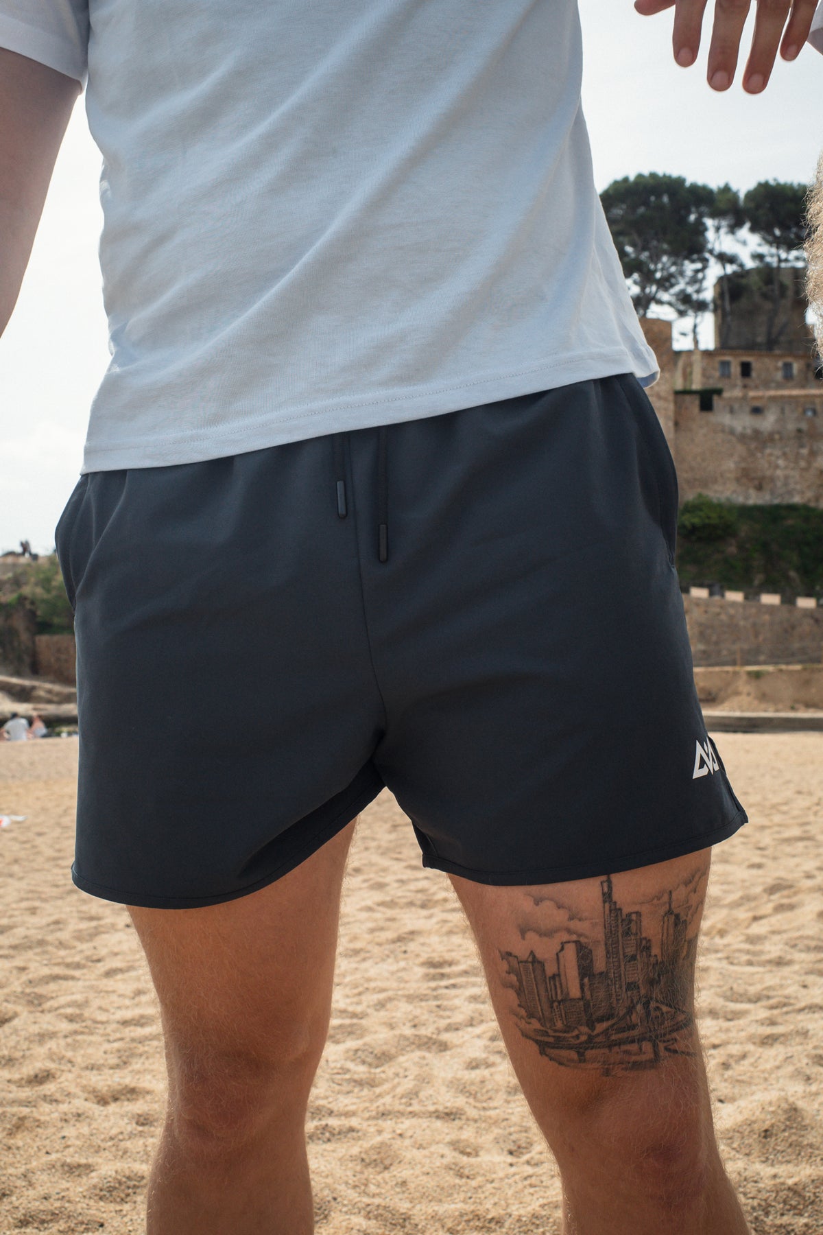 Navy blue athletic shorts front fit with black drawstrings on beach