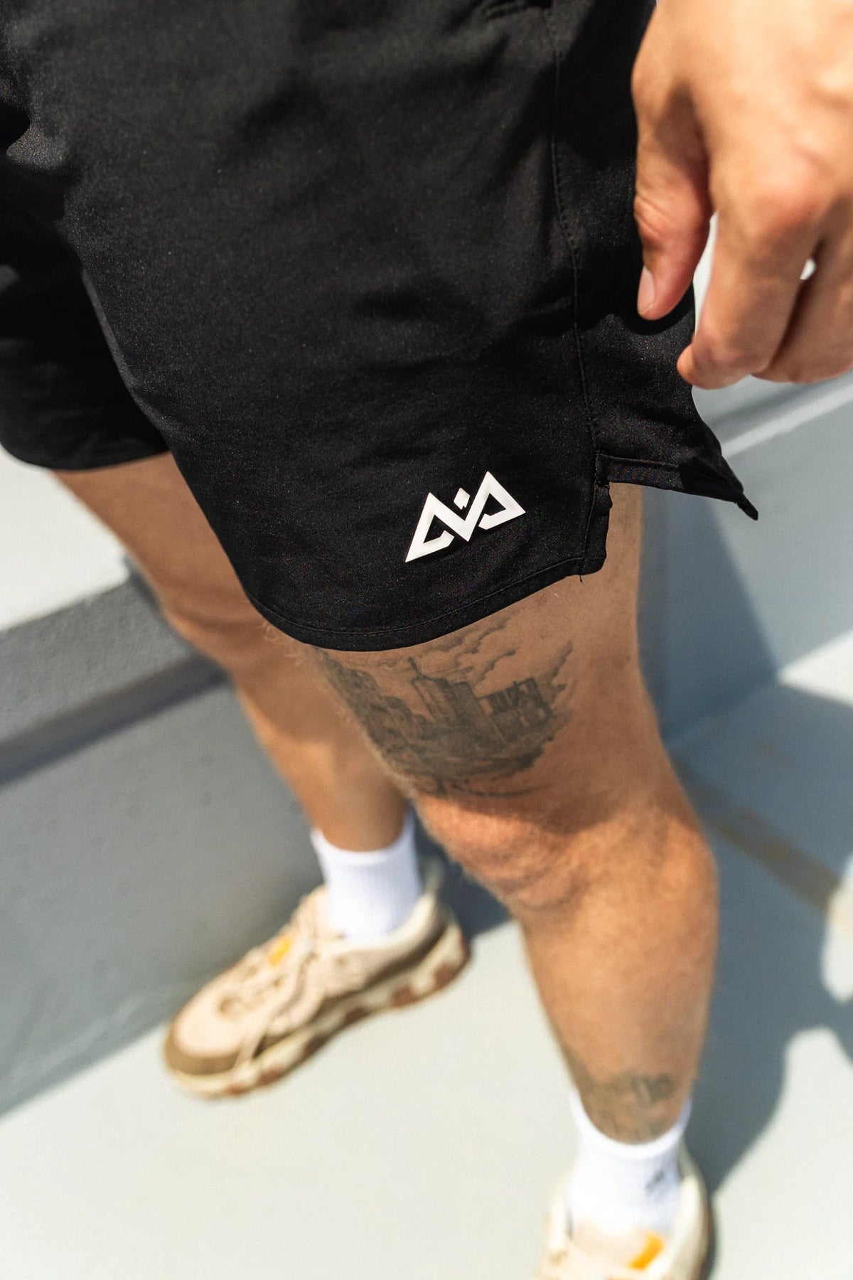 Detailansicht des weißen Logos an der schwarzen Sportshorte