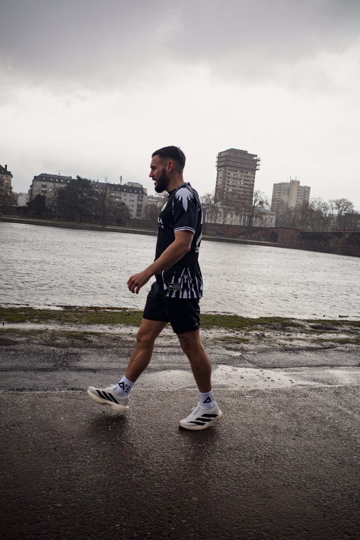Man walking in black short-sleeve jersey with side graphics