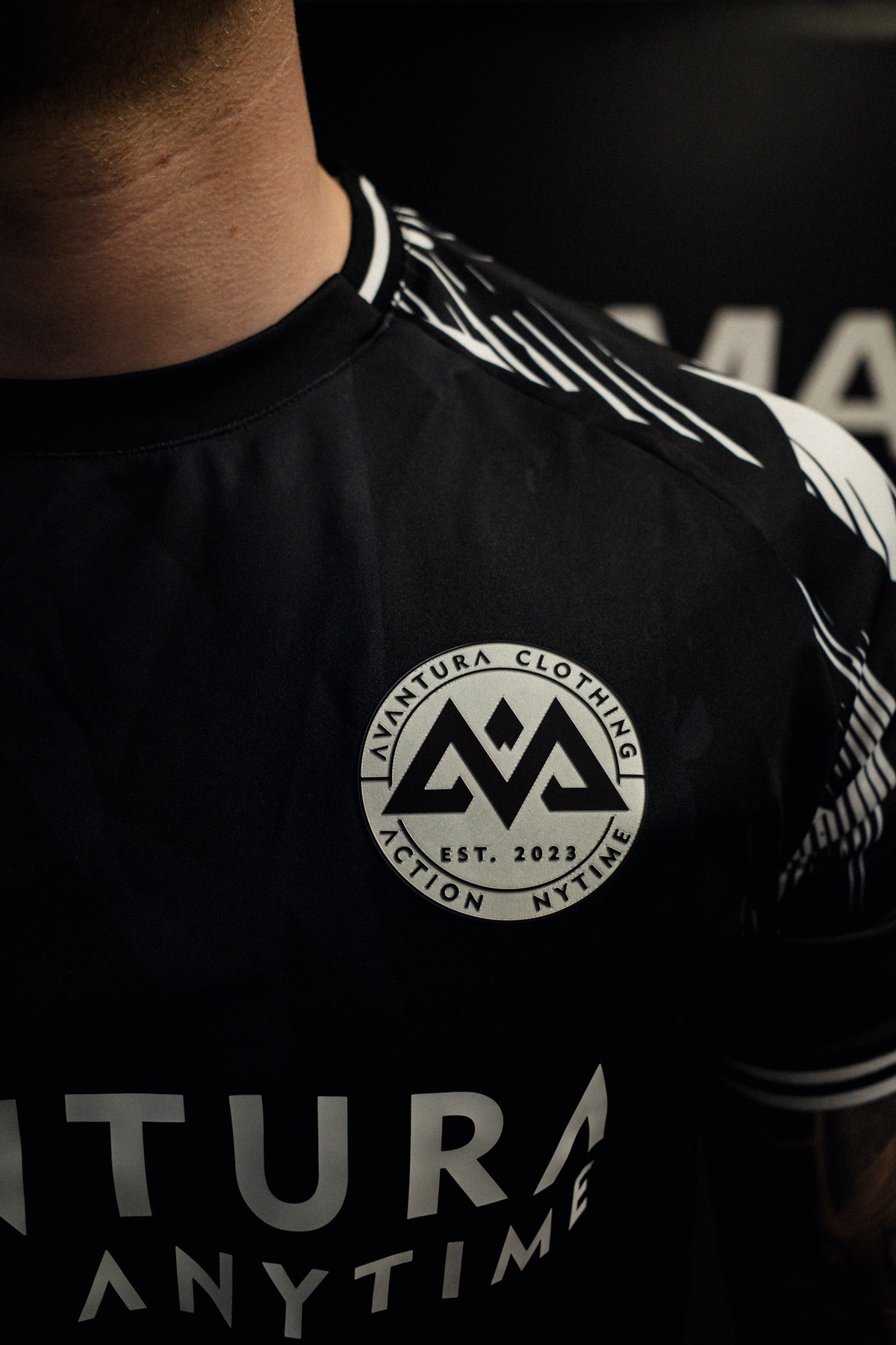 Macro shot of woven label and neckline detail on black jersey