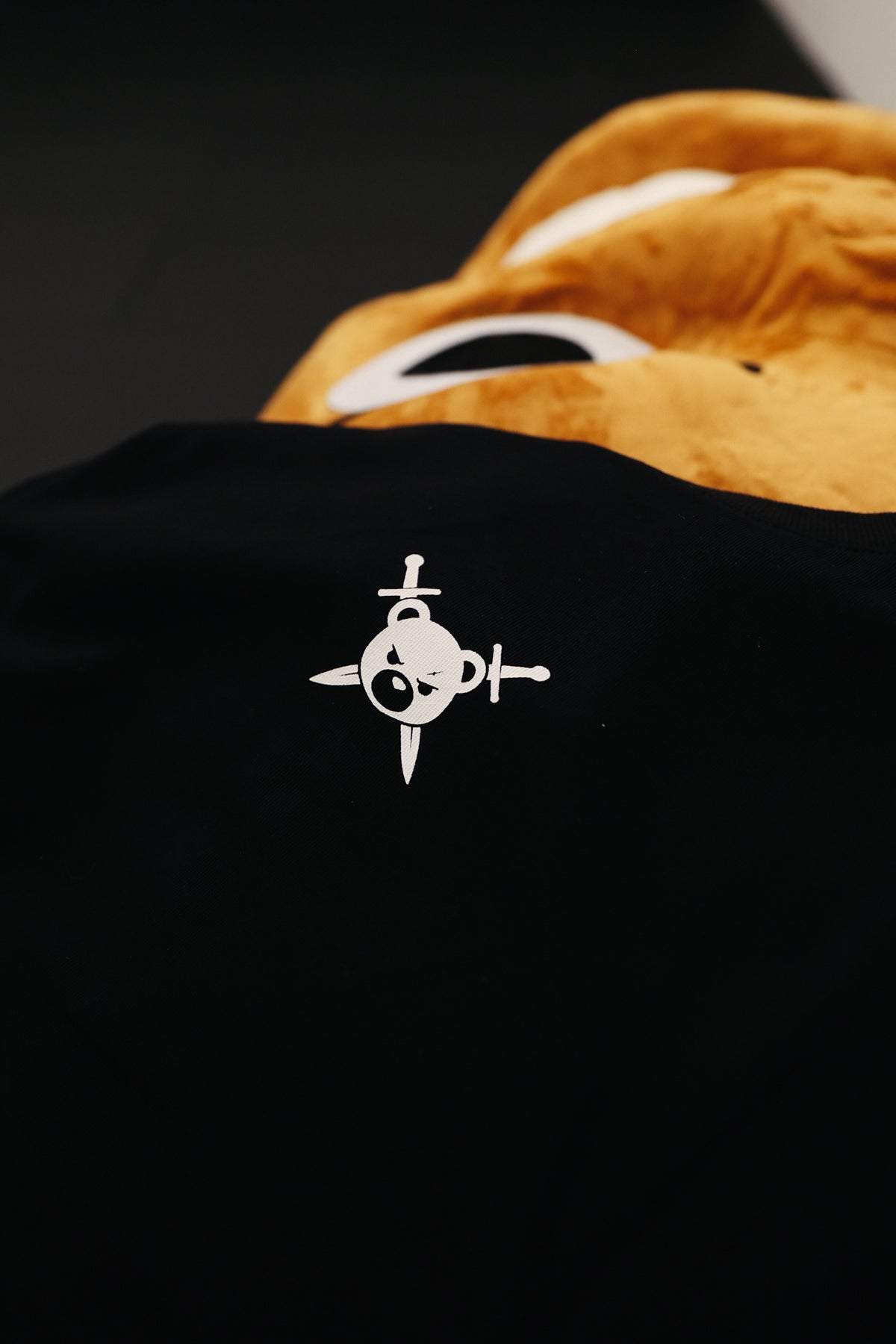 Close-up of white AVANTURA logo on black T-shirt fabric