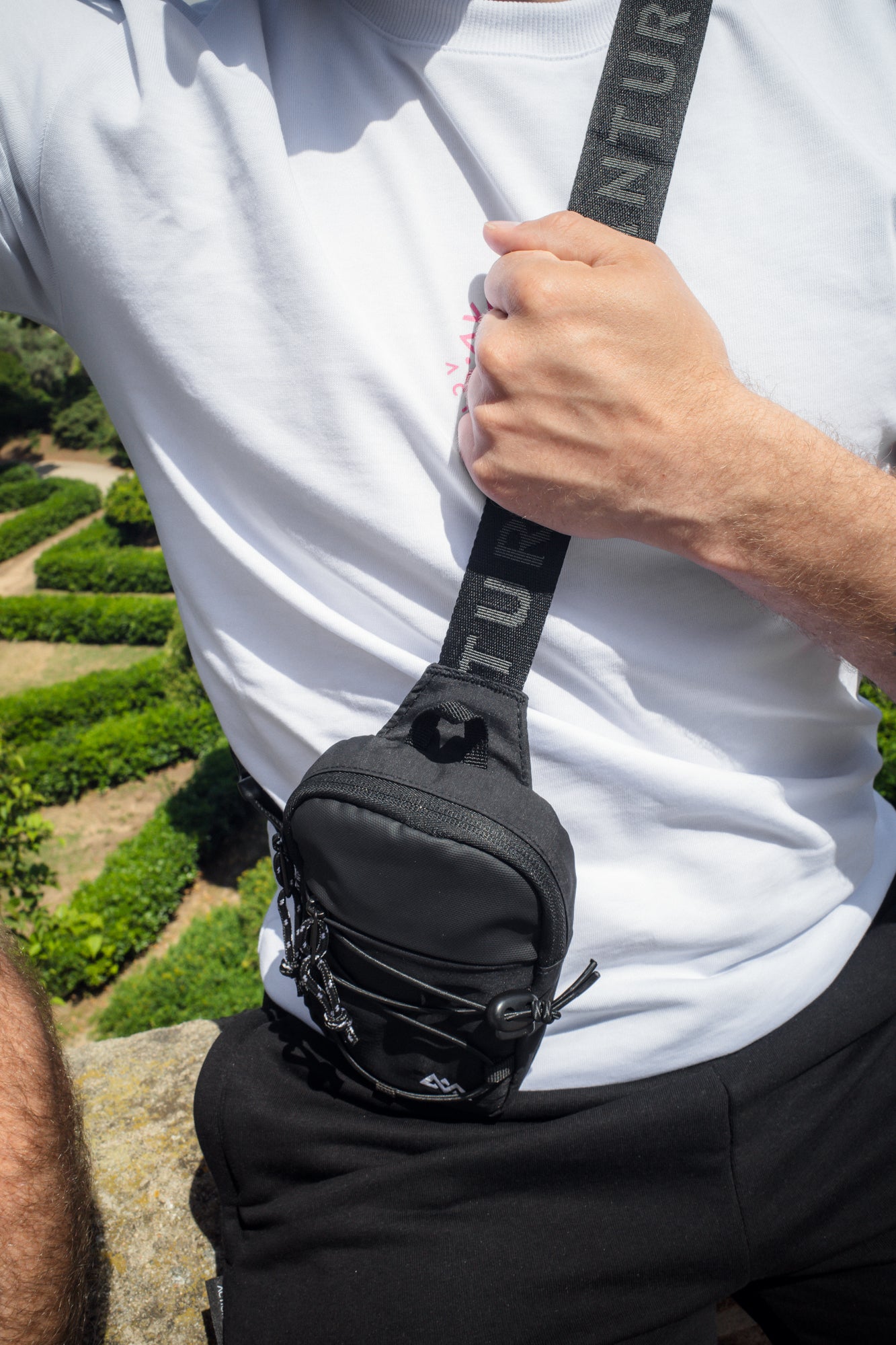 Black pusher bag worn crossbody on hip