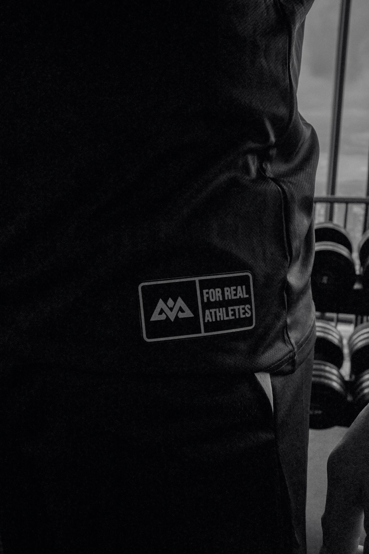 Close-up of silicone patch logo on sleeve of black athletic tank top