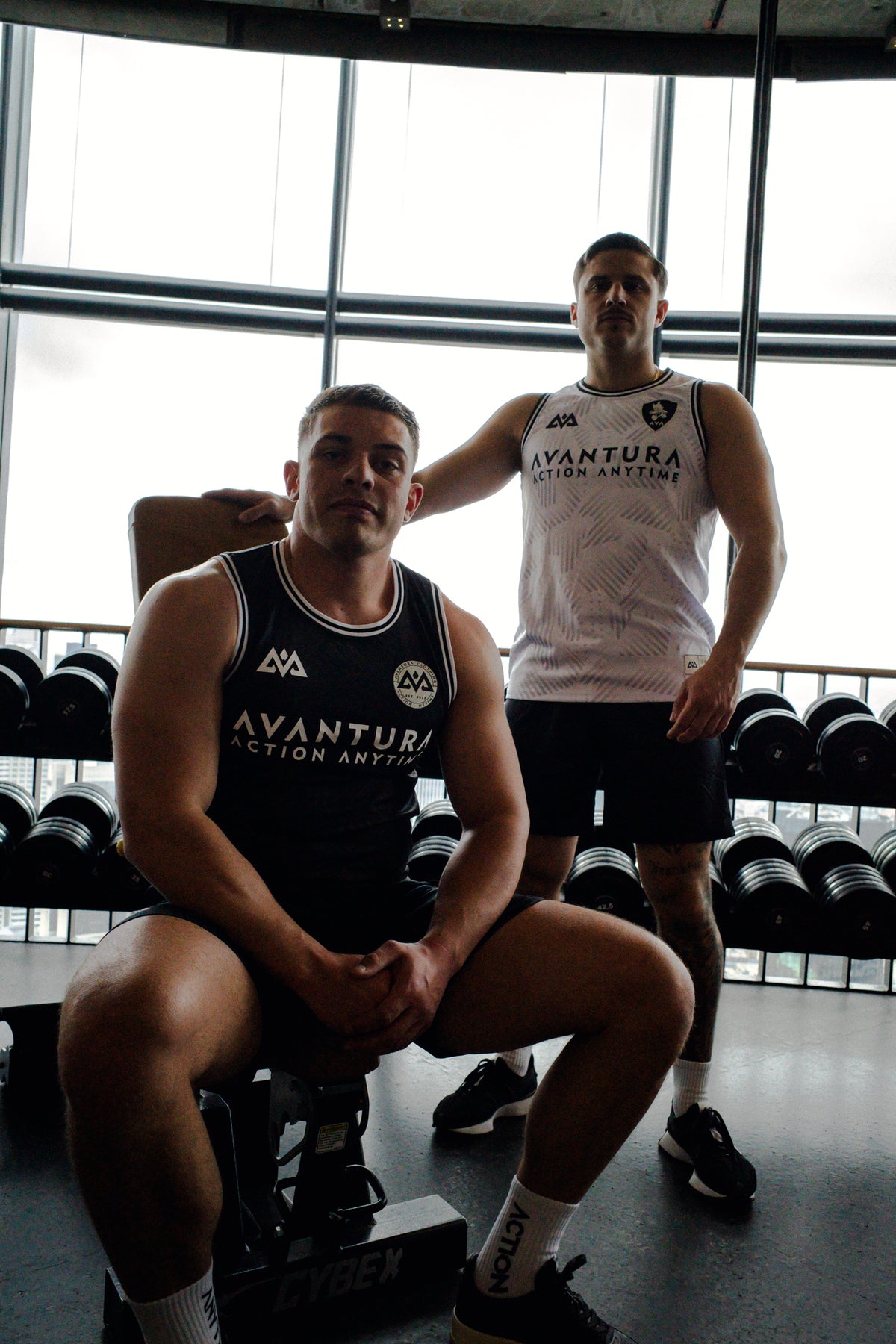 Gym scene featuring black and white Avantura tank tops with logo details