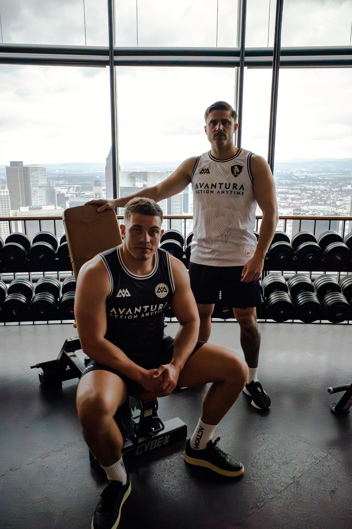 Comparison of white and black Avantura sleeveless jerseys in gym setting