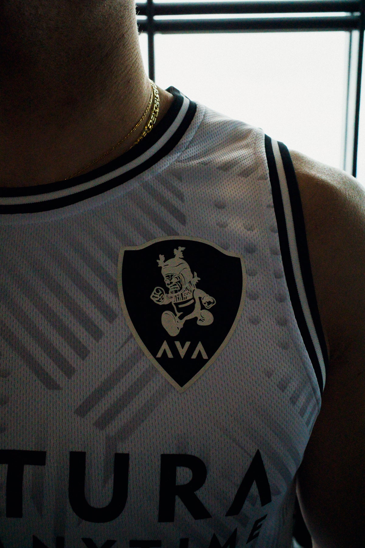 Detail of shield logo with Viking graphic on left chest of white tank
