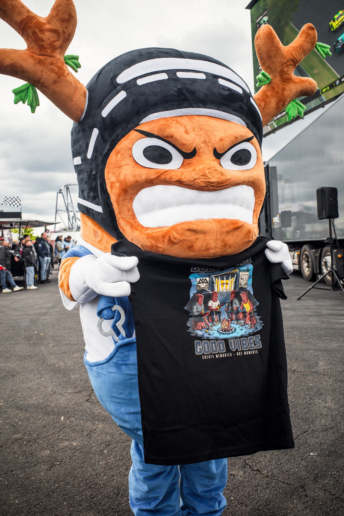 Person displaying black Avantura X Bembel collaboration T-shirt back design at festival