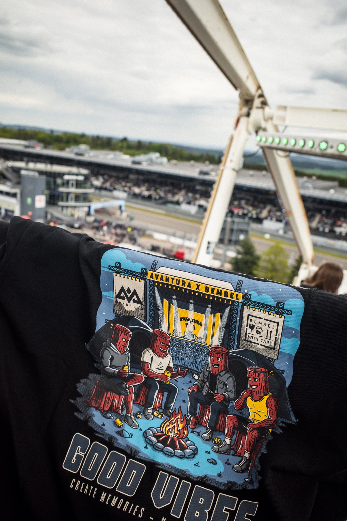 Back print detail of black Avantura T-shirt featuring cartoon logs and campfire graphic