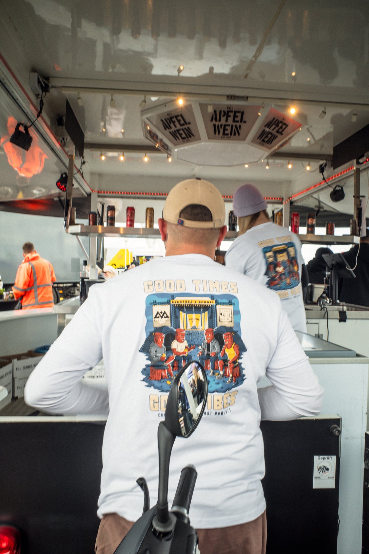 Two men in white t-shirts with matching back prints near food truck
