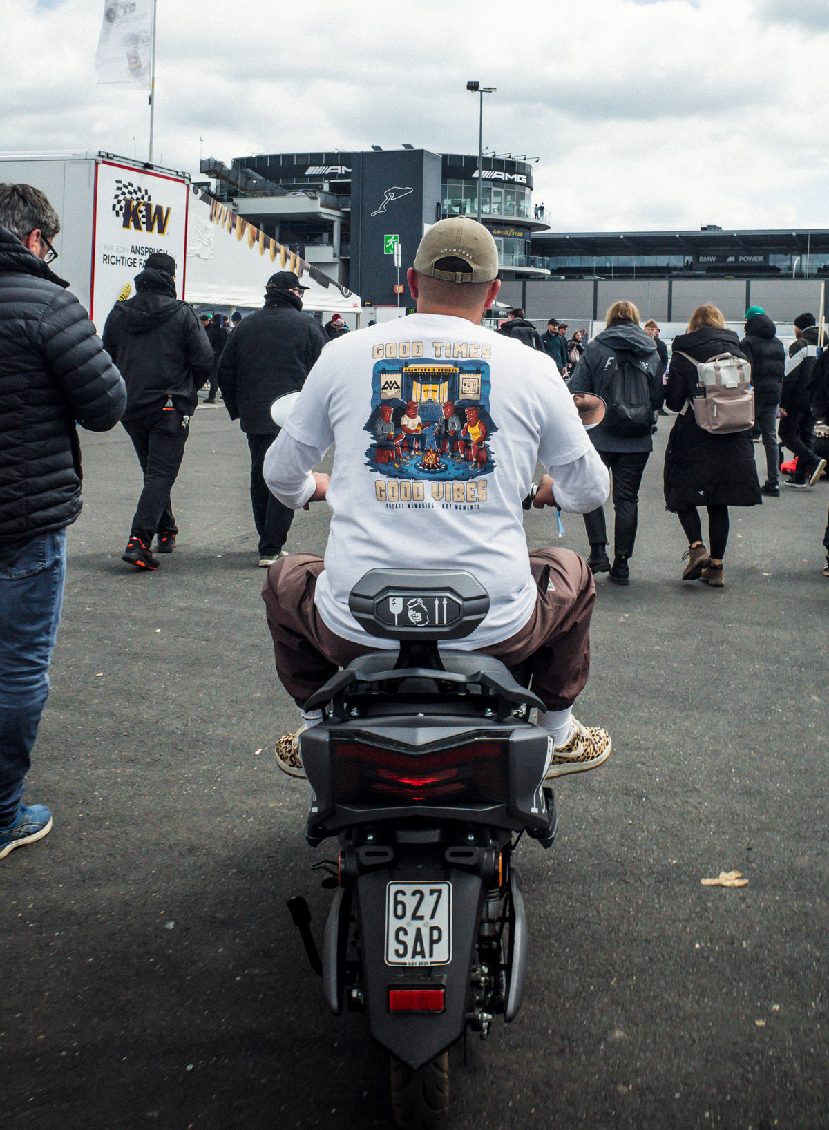 Man on scooter wearing white t-shirt with large red campfire back print