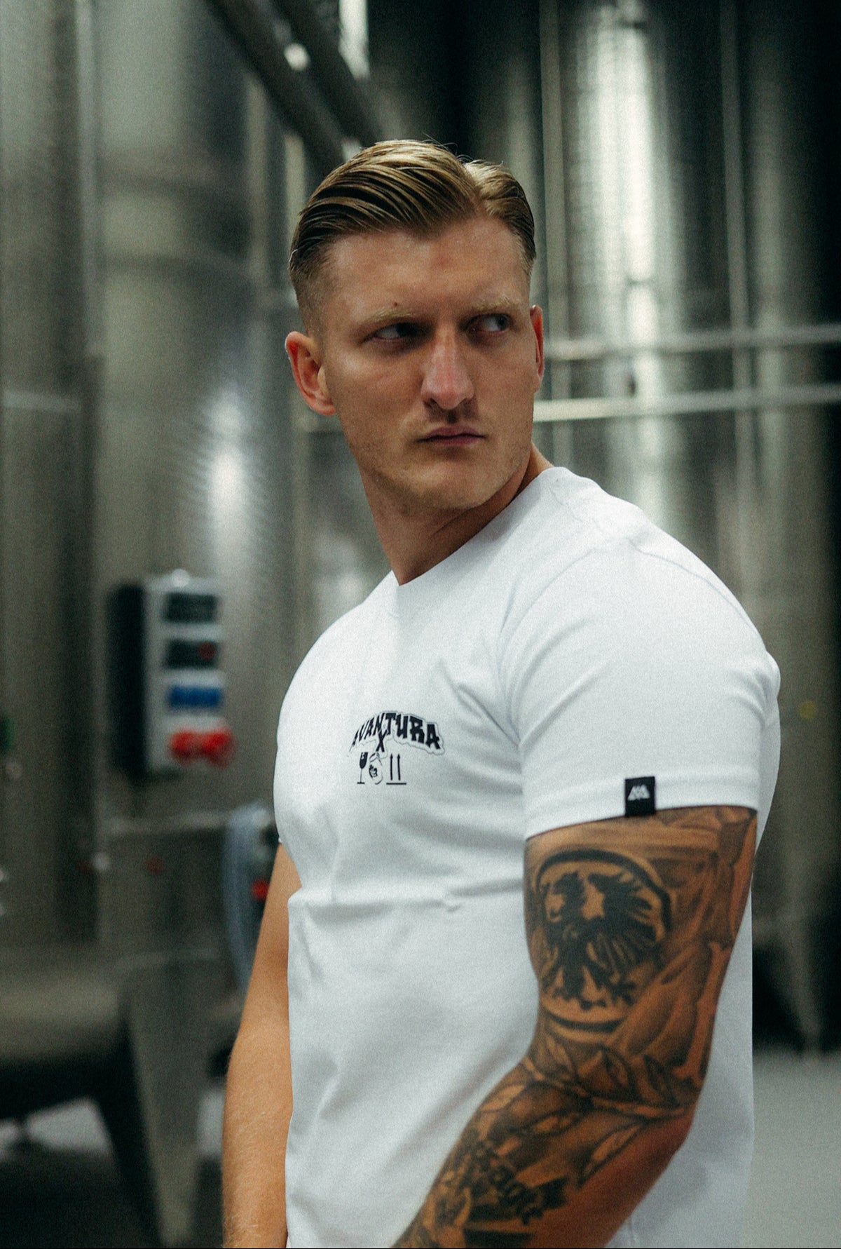 Man wearing white Avantura collaboration T-shirt fit