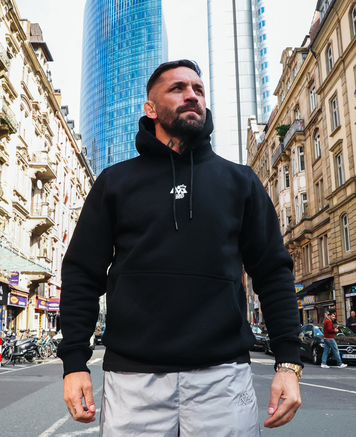 Black hooded sweatshirt with white chest logo and drawstrings, urban style
