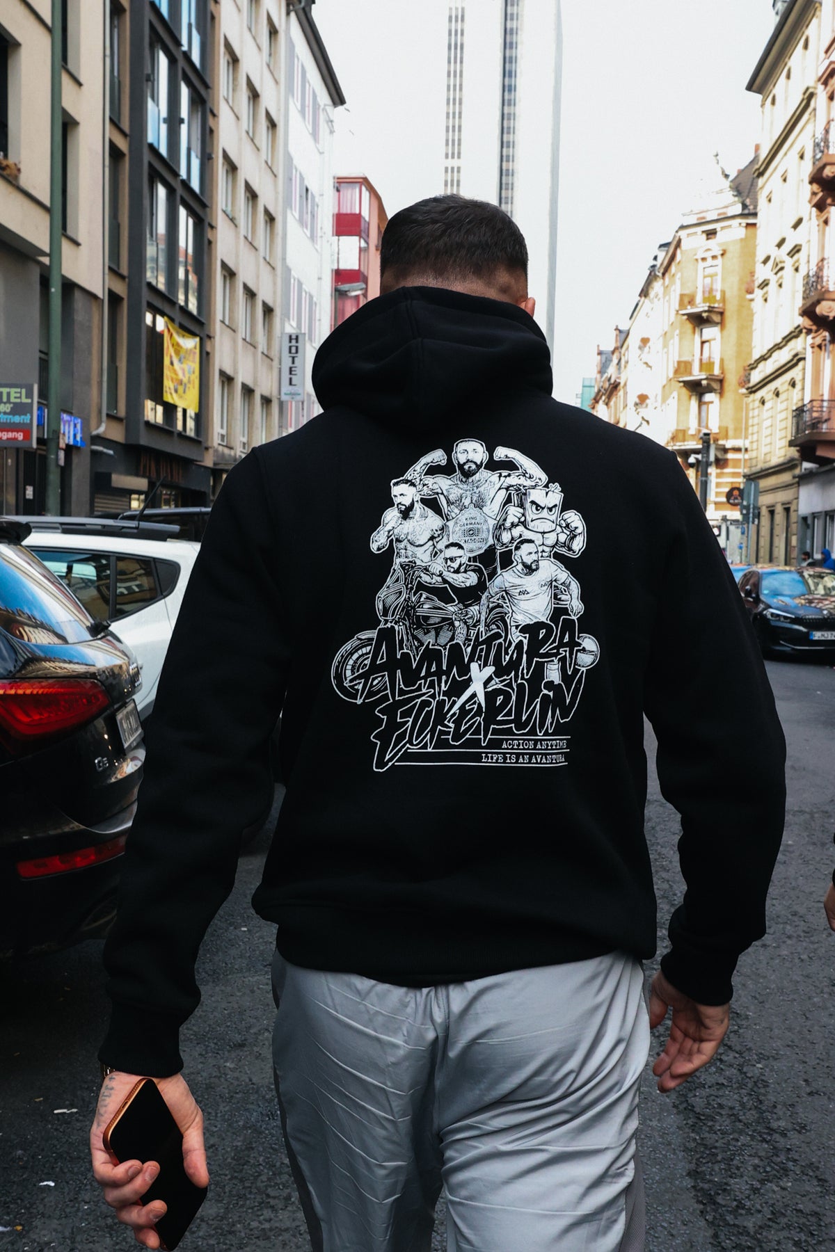 Back detail of black hoodie showing 'Avantura Eckerlin' graphic print