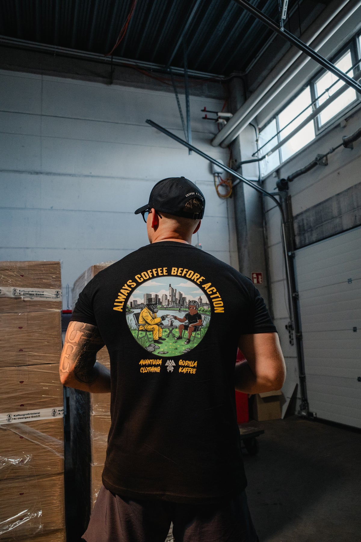 Back view of black t-shirt featuring large 'Always Coffee Before Action' gorilla graphic