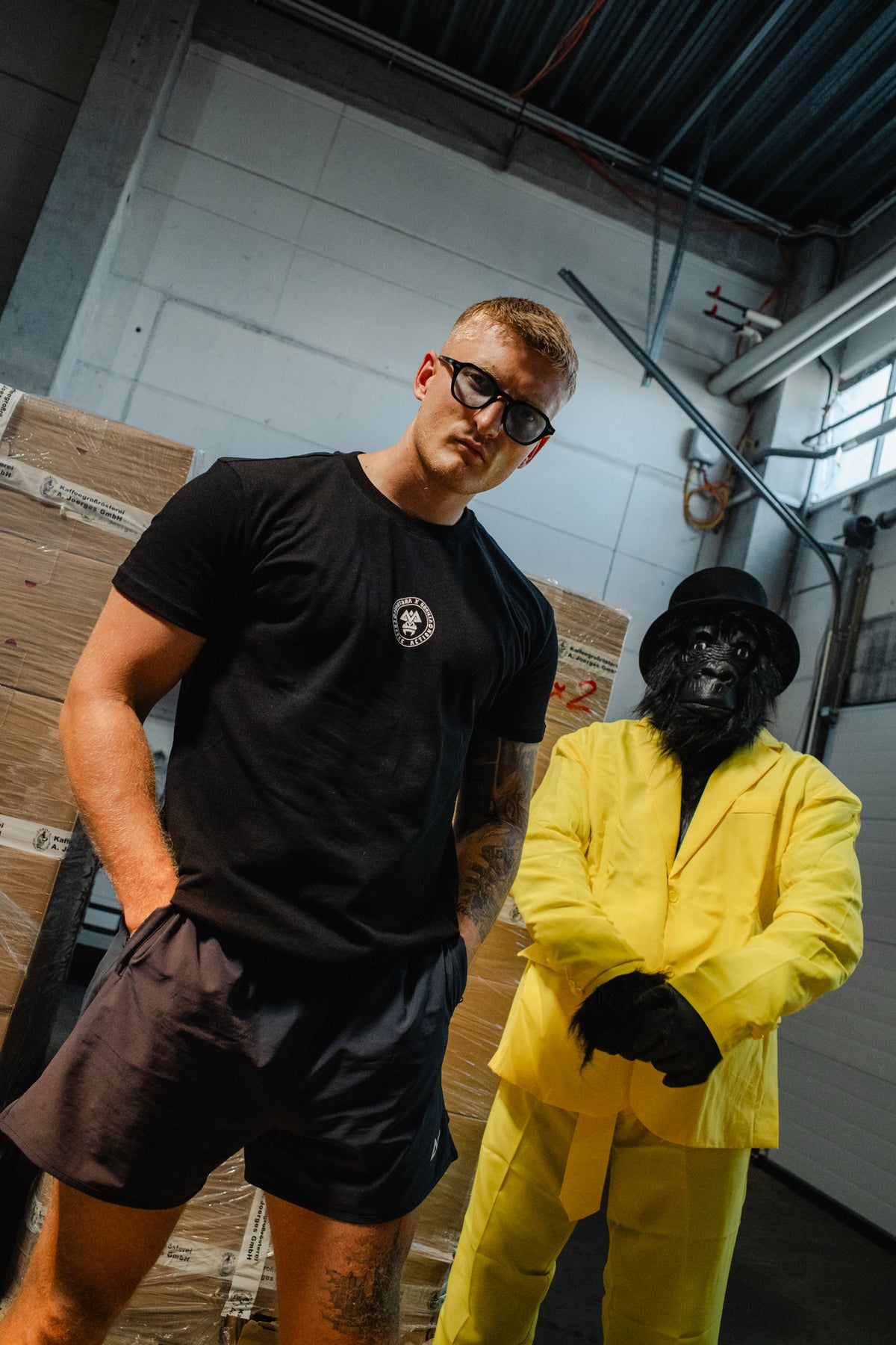 Black crew neck t-shirt with small white circular logo on left chest worn by model