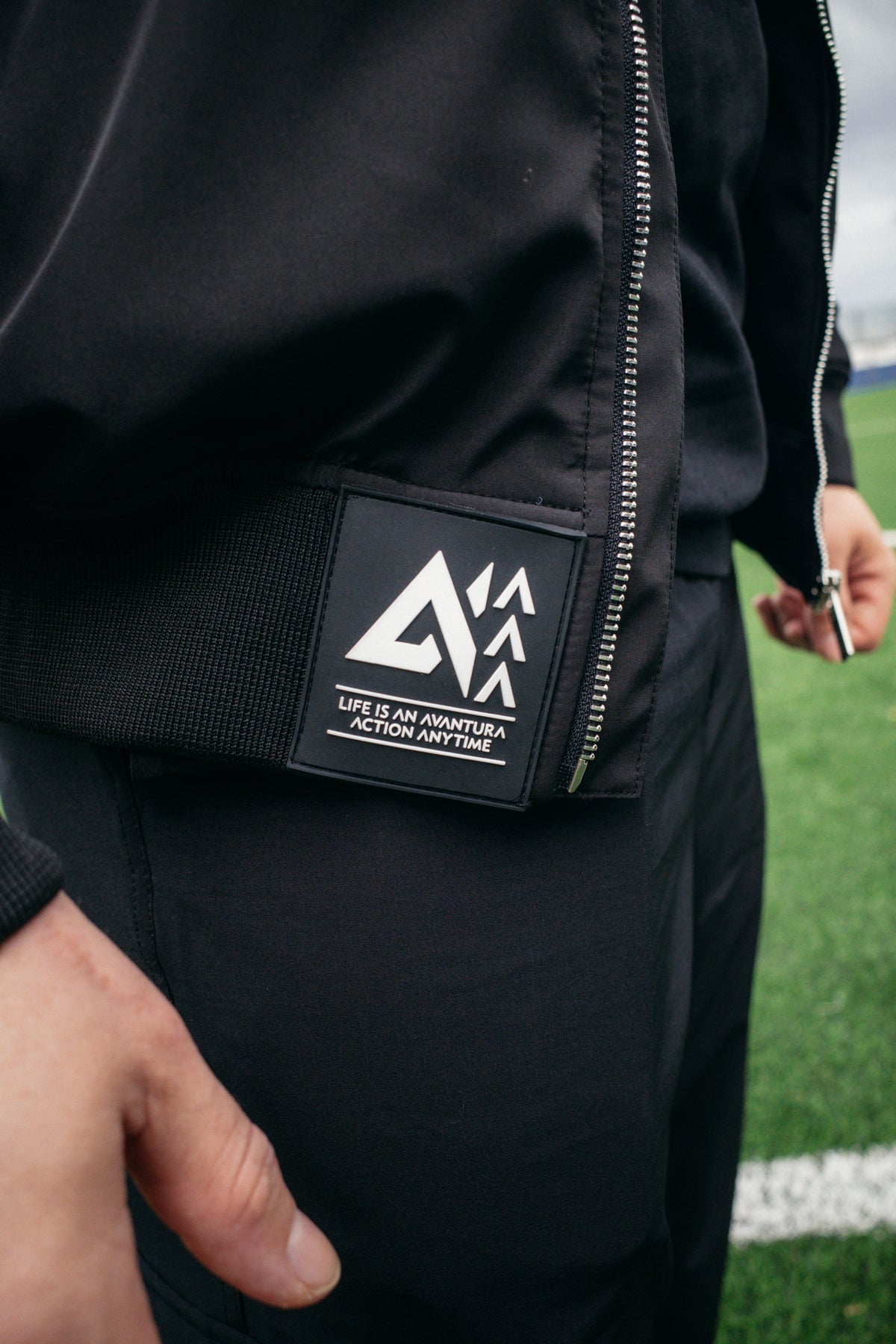 Close-up of black bomber jacket branded rubber patch