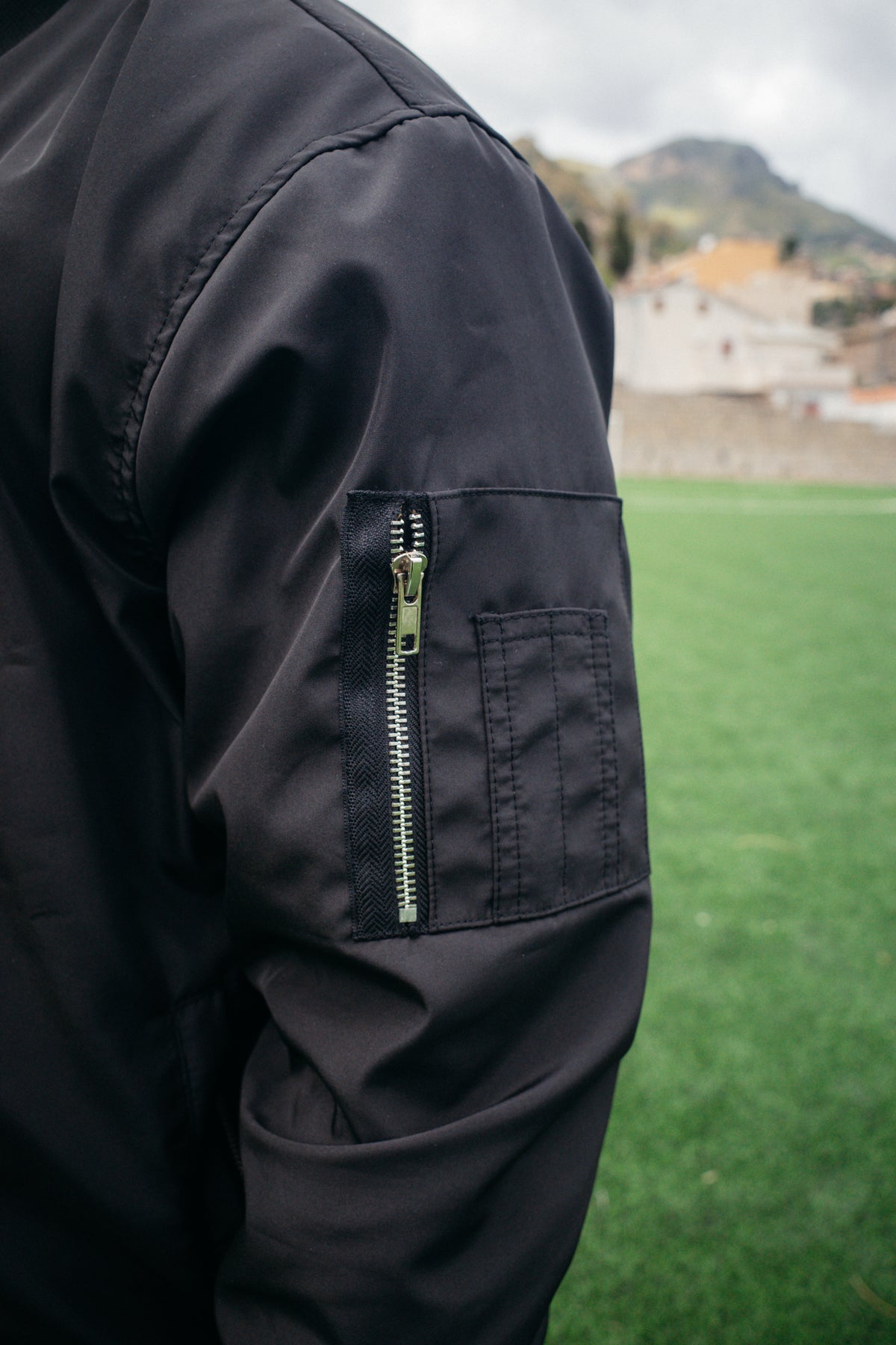 Black bomber jacket side zippered pocket detail