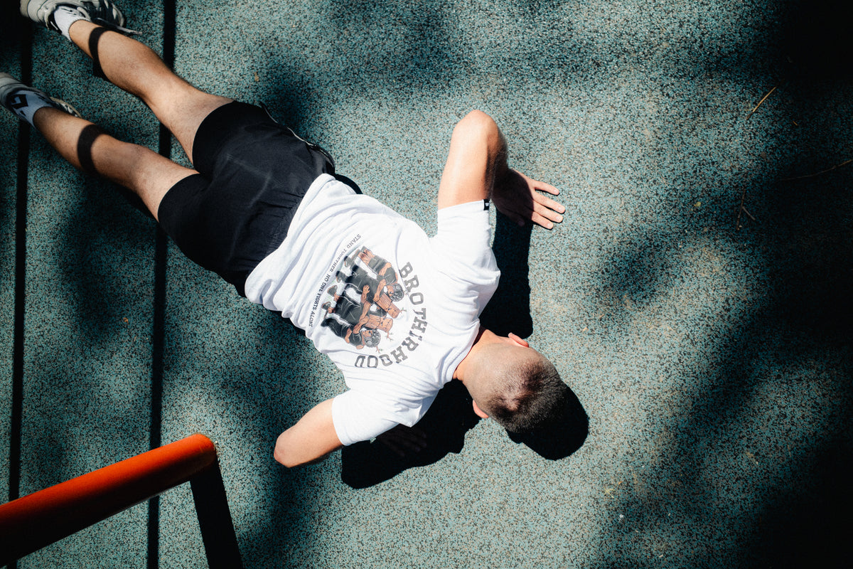 Man doing push-ups wearing white t-shirt with Brotherhood back print