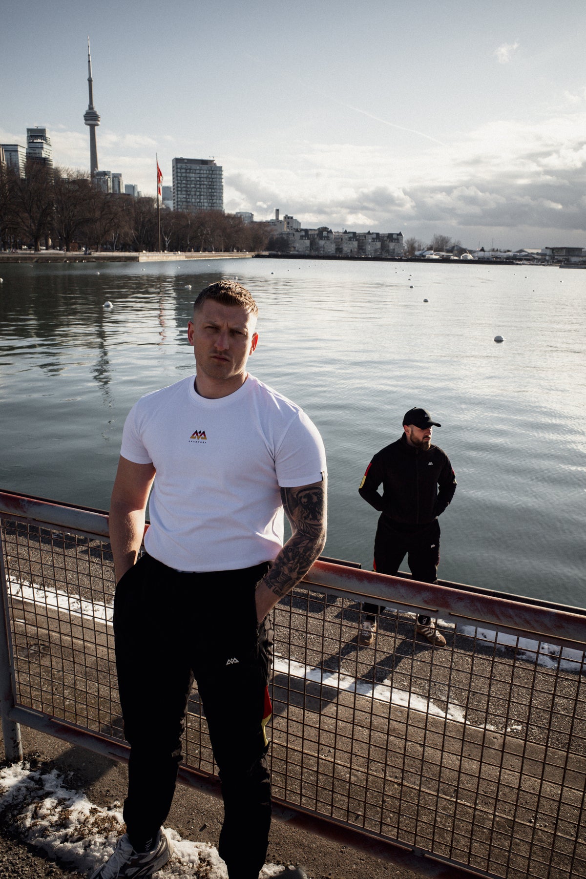 Ganzkörperaufnahme weißes T-Shirt mit Brustlogo im urbanen Setting