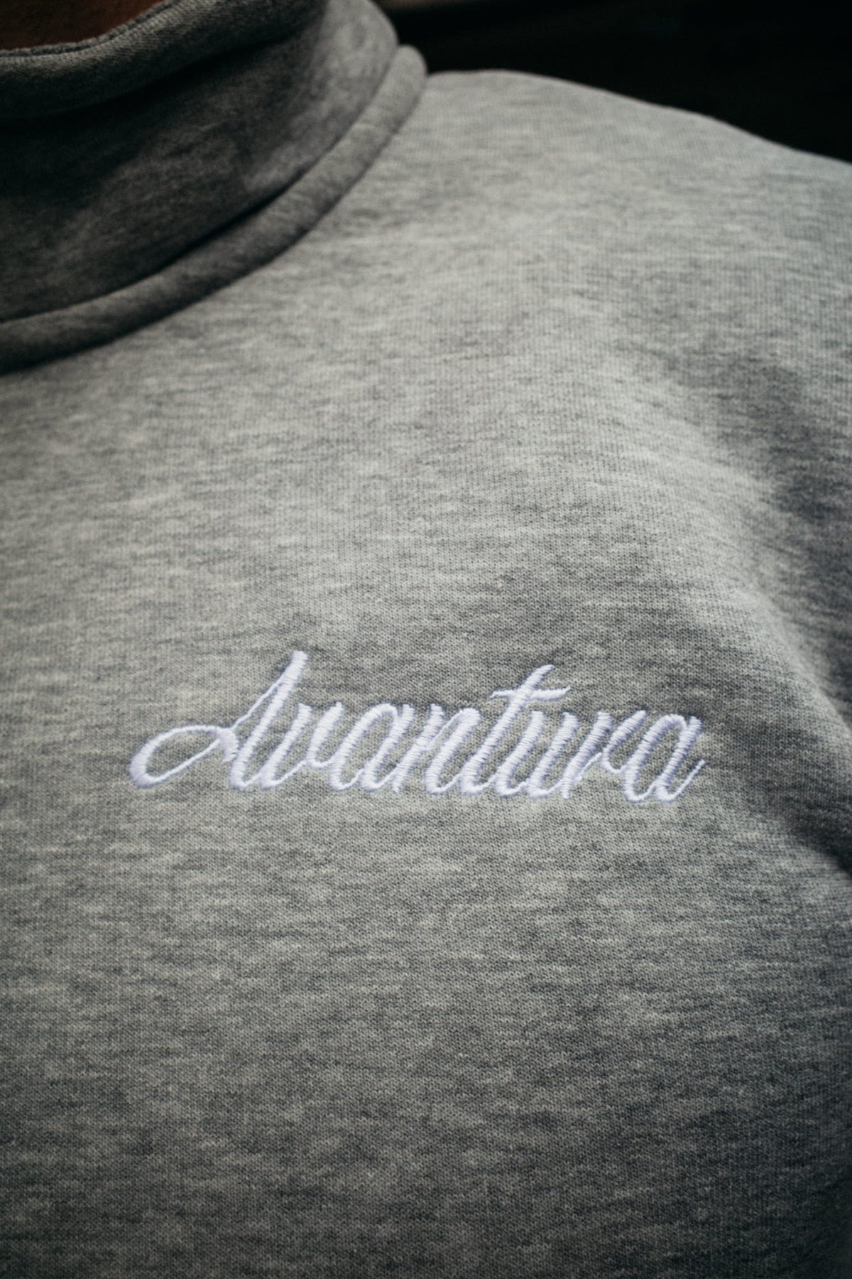 Macro shot of raised Avventura embroidery on heather gray sweatshirt