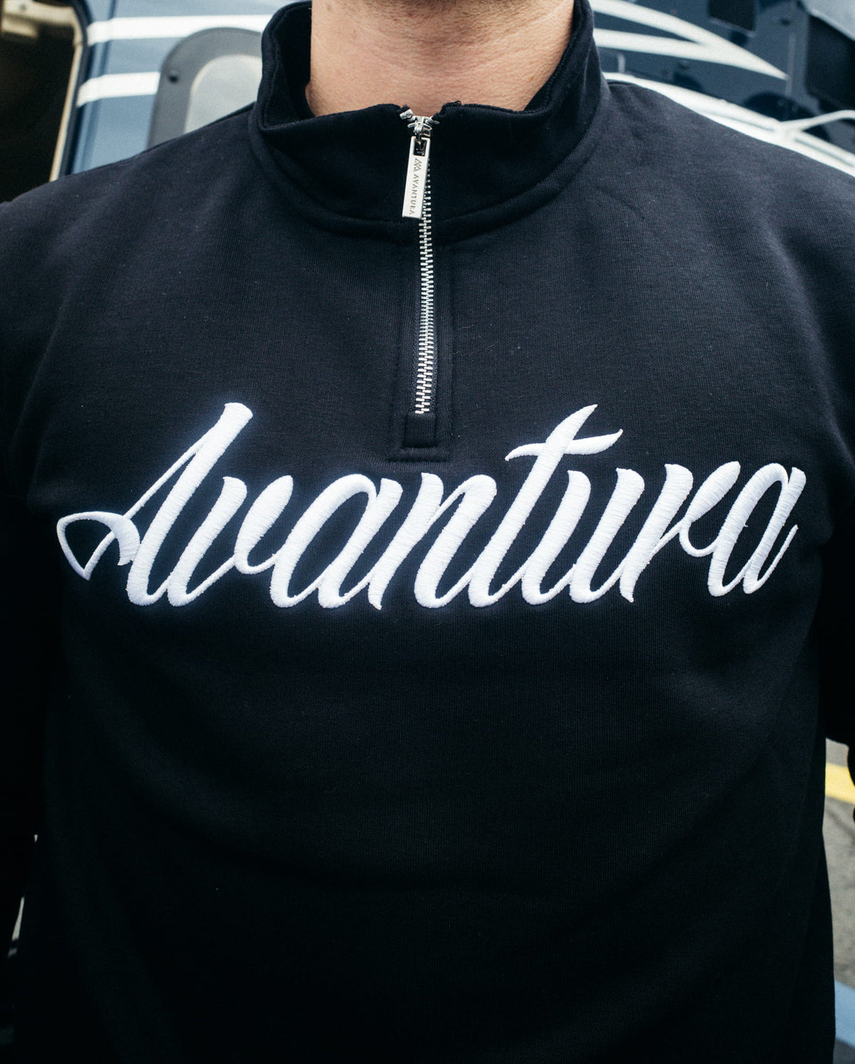 Large white cursive logo on the chest of the black sweatshirt