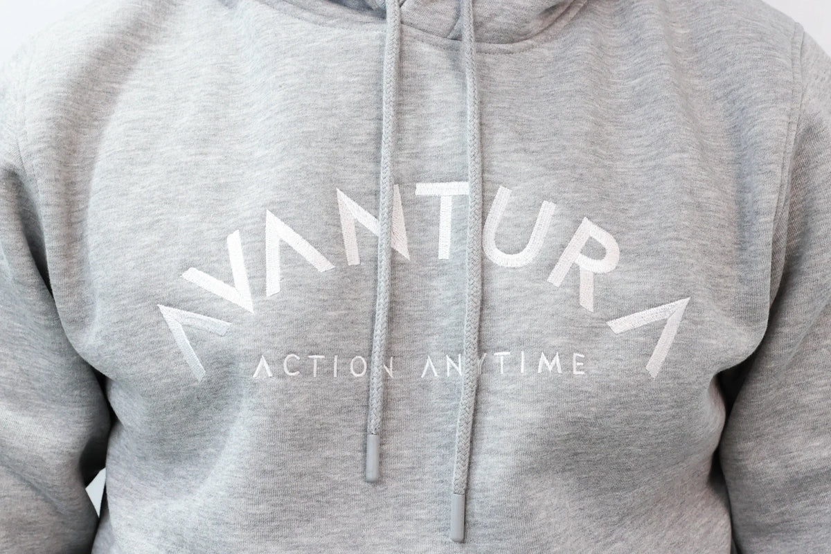 Close-up of embroidered 'Avantura' text on grey hoodie