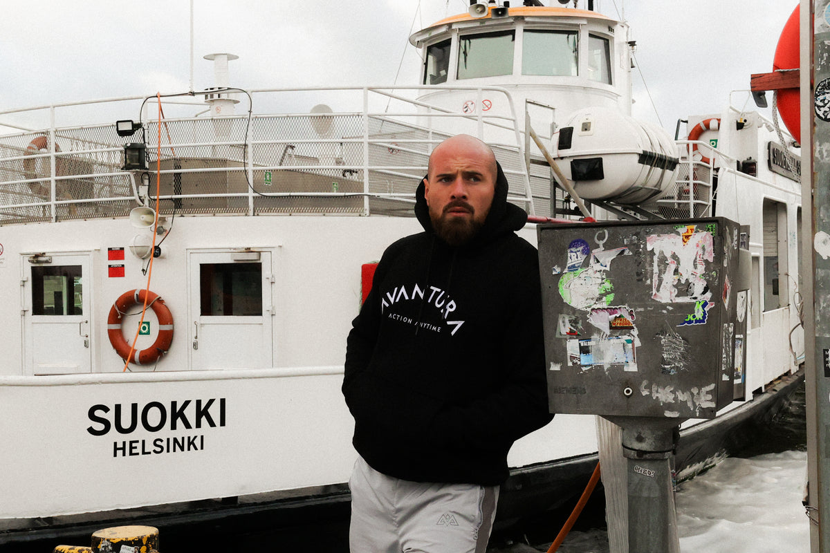 Schwarzer Hoodie mit Logo an einem Hafen in Helsinki getragen