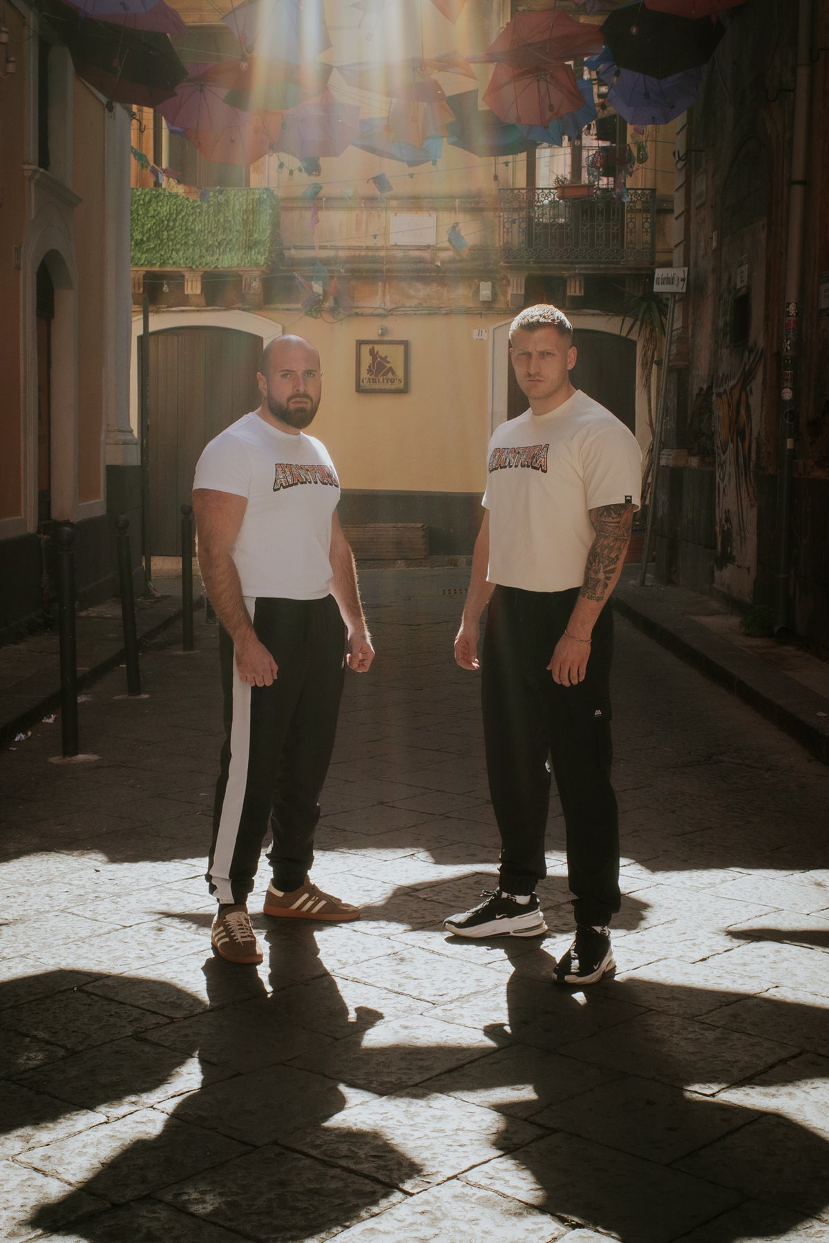 White T-shirts with central Avventura logo worn under umbrellas