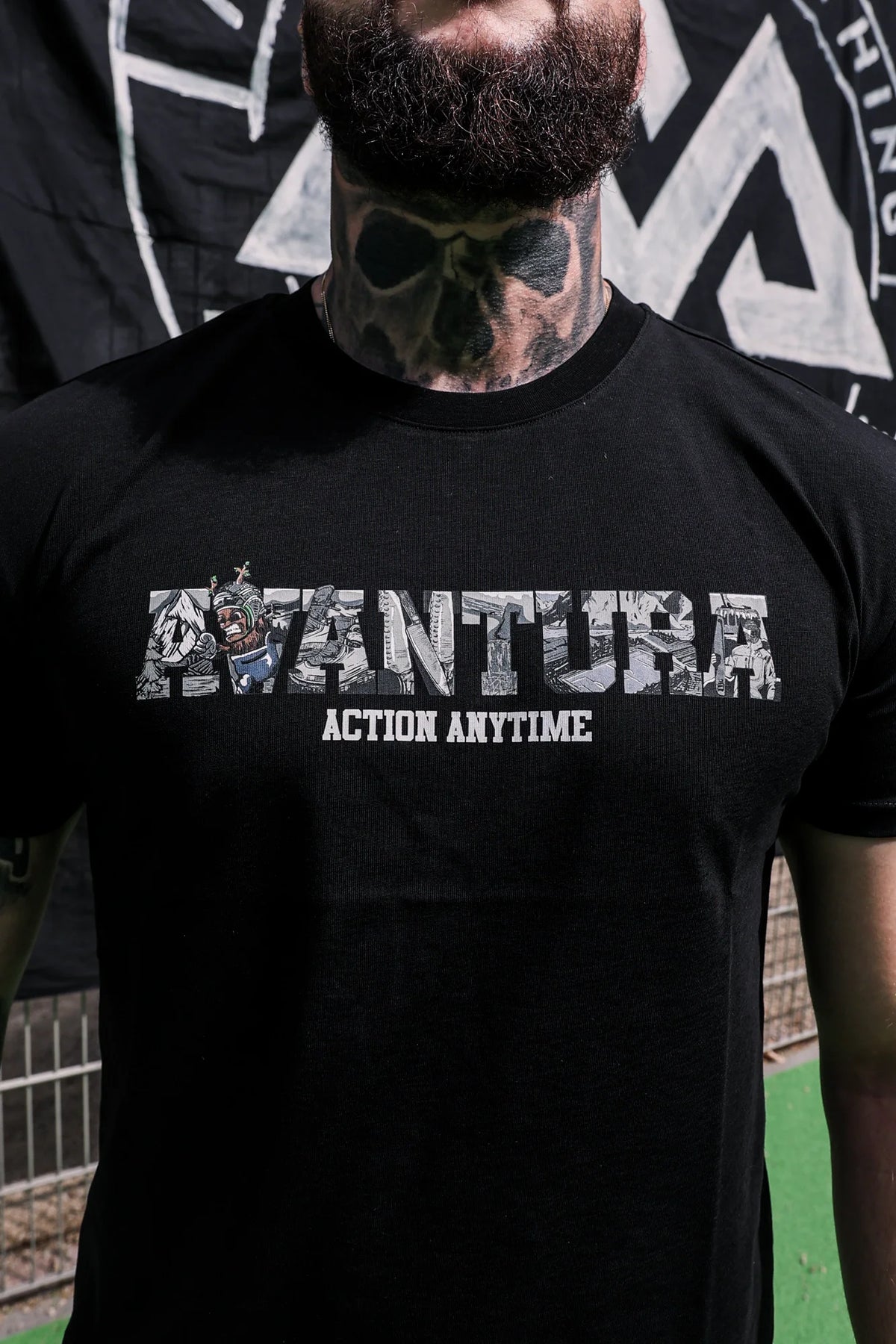Close-up of filled letter graphic design on black Avantura T-shirt chest