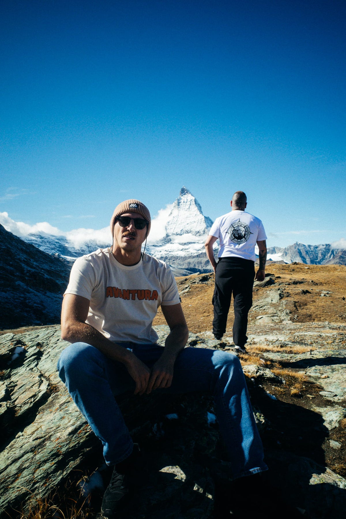 Hiker in hellgrauem AVANTURA T-Shirt und Mütze in der Berglandschaft