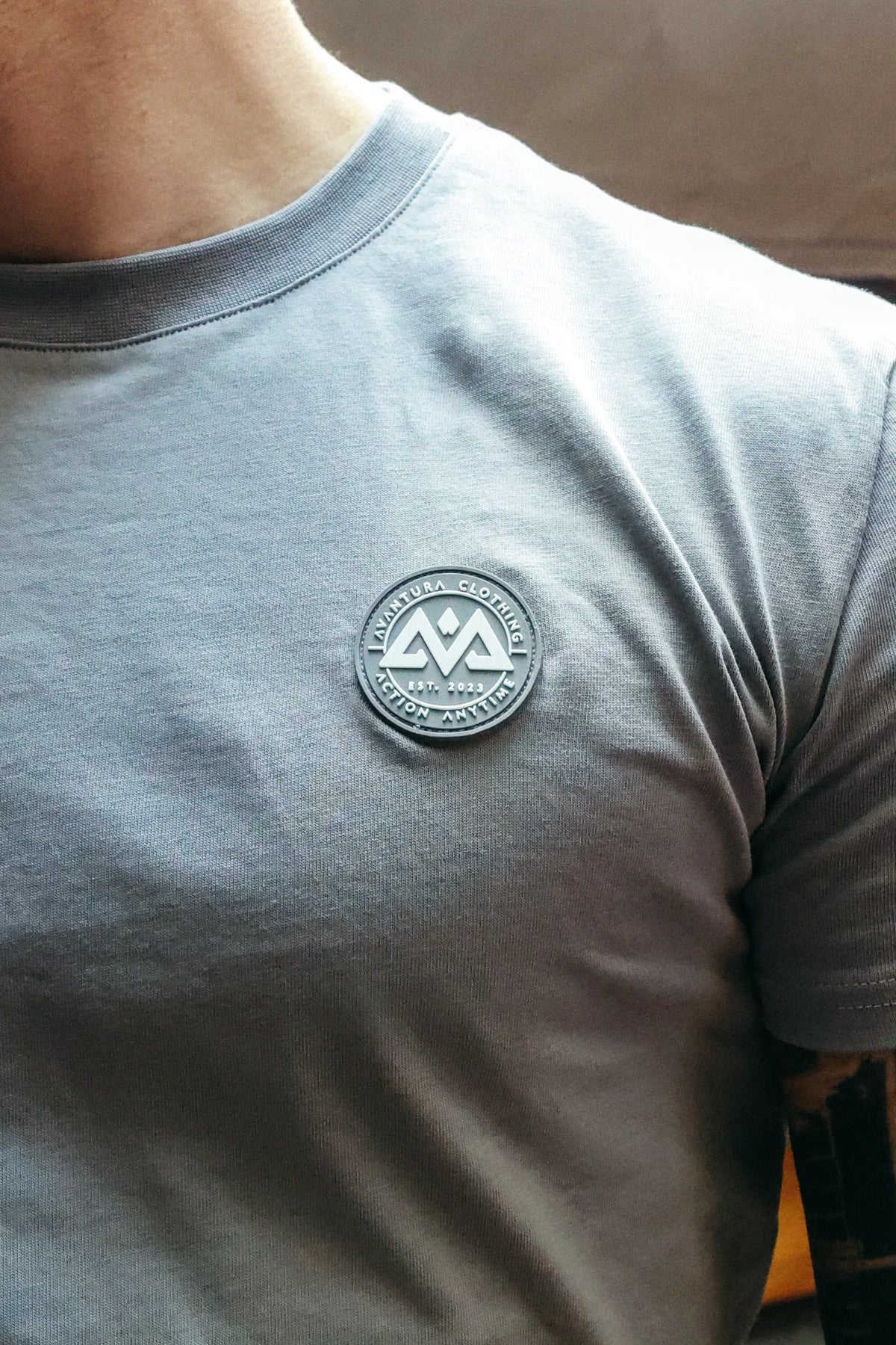 Close-up of the grey Rubber logo with AVANTURA CLOTHING text on the T-shirt