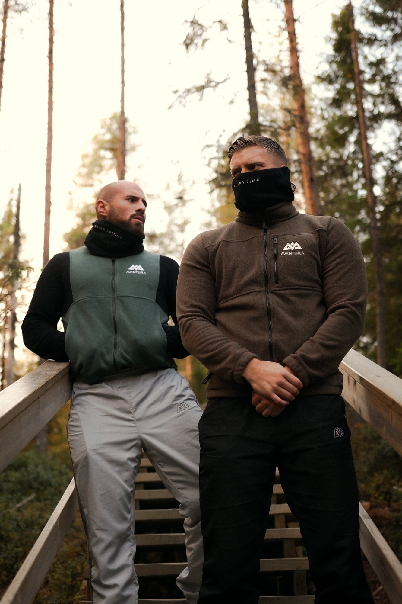 Men wearing brown and green Avantura fleece jackets in forest setting