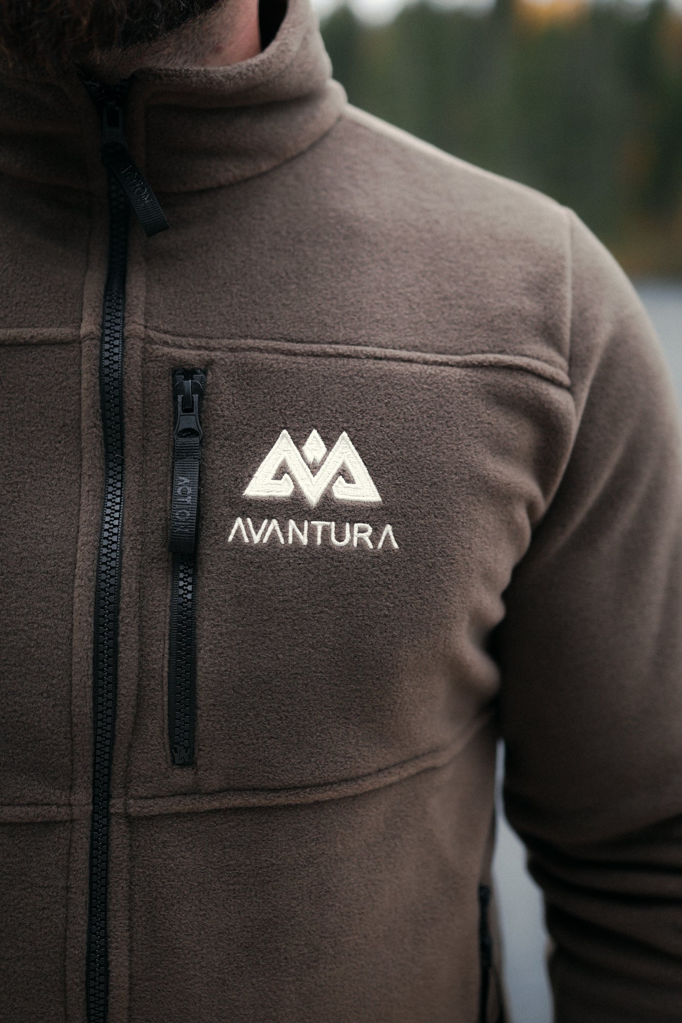 Detail of brown fleece texture, zipper, and embroidered Avantura logo