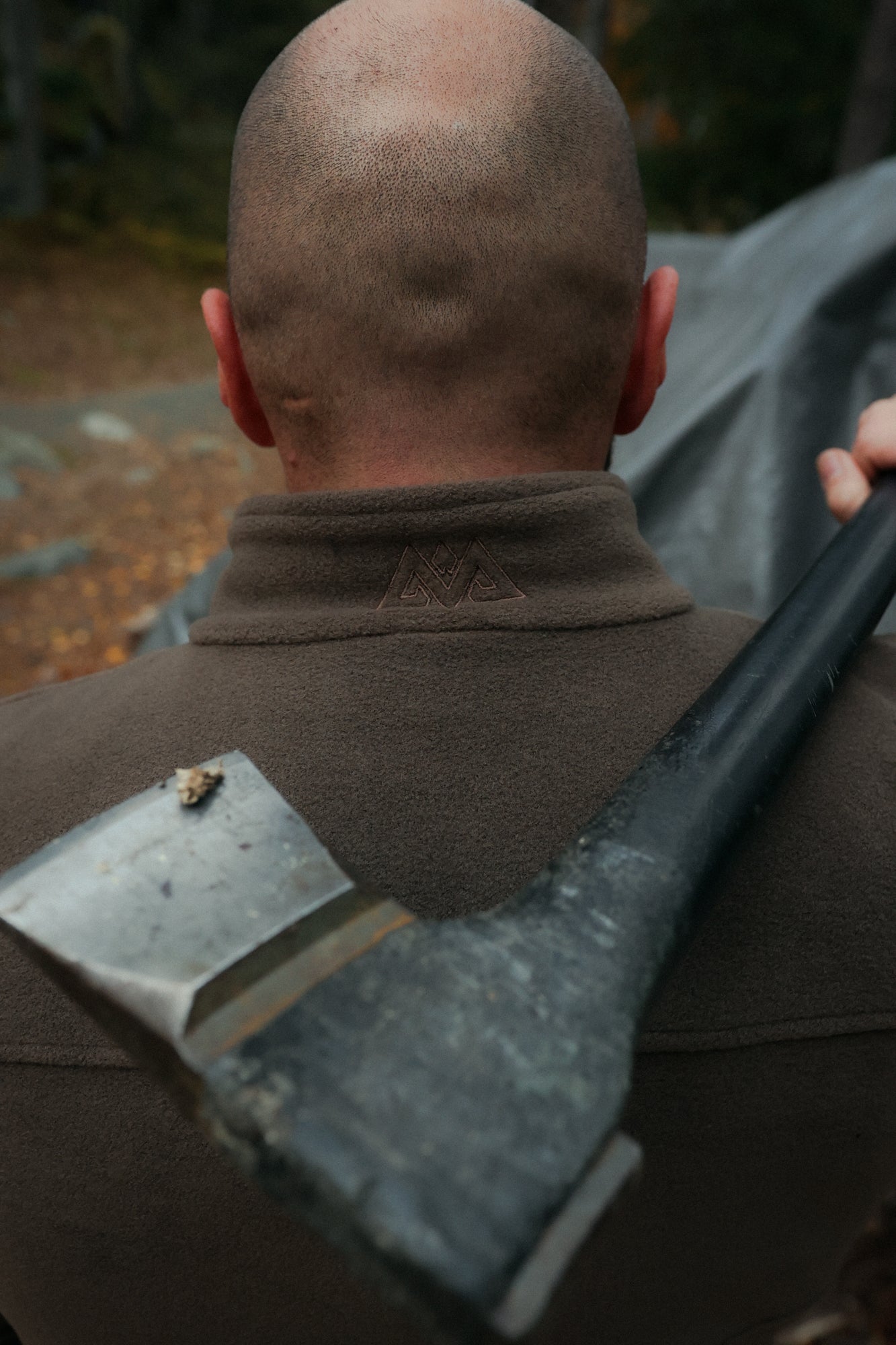 Close-up of embroidered mountain logo on brown fleece jacket collar