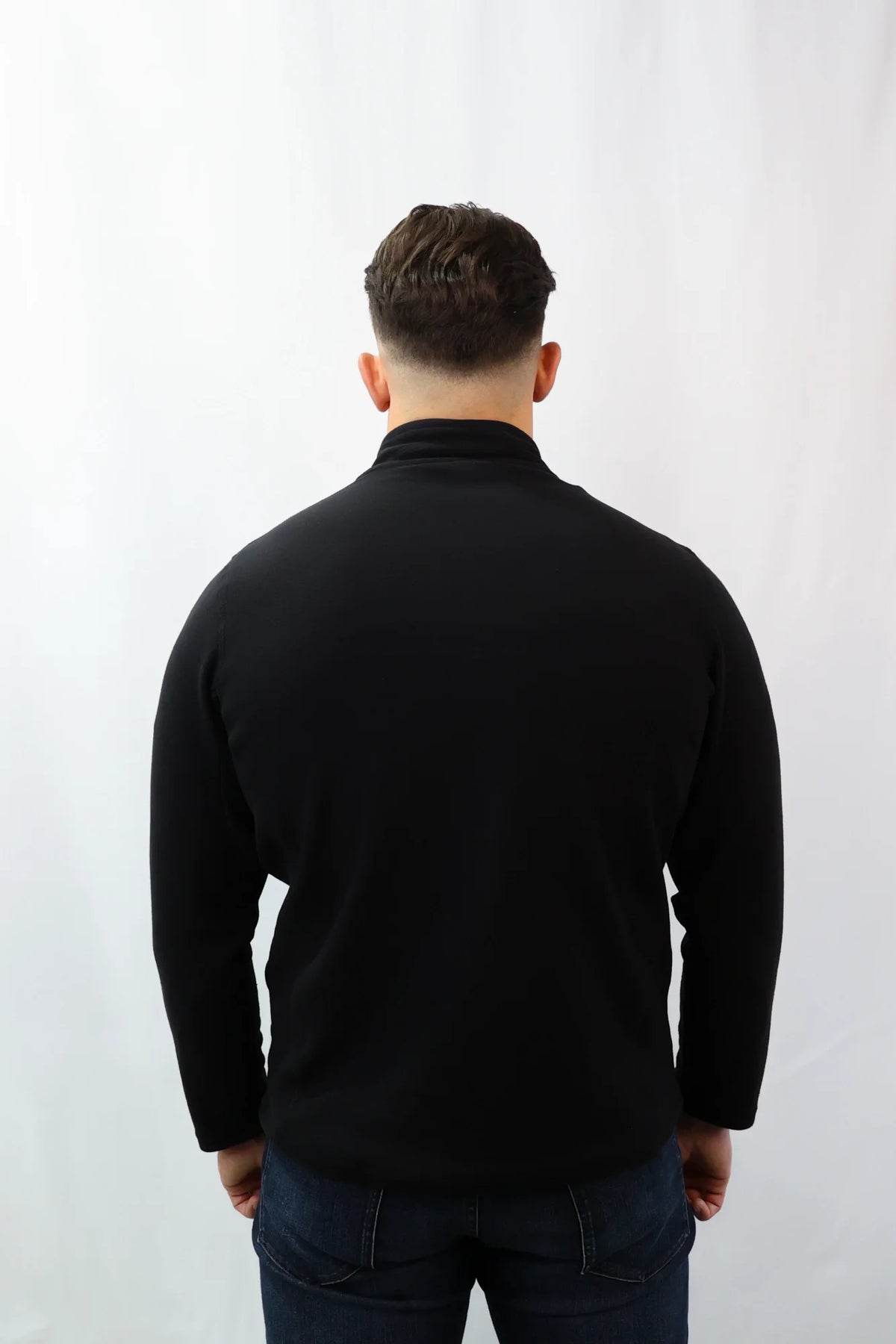 Rückansicht schwarzes Halfzip Fleece kombiniert mit blauer Jeans