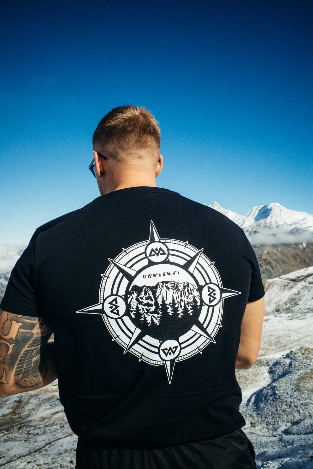 Black T-shirt with large white compass mountain graphic on the back