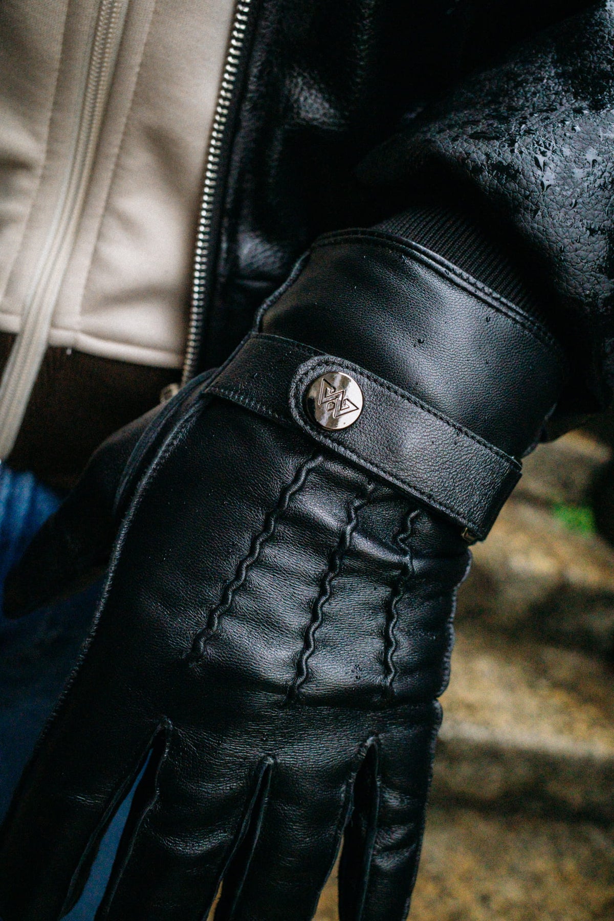 Geschlitzter Bund mit silbernem Logo-Knopf am Handschuh