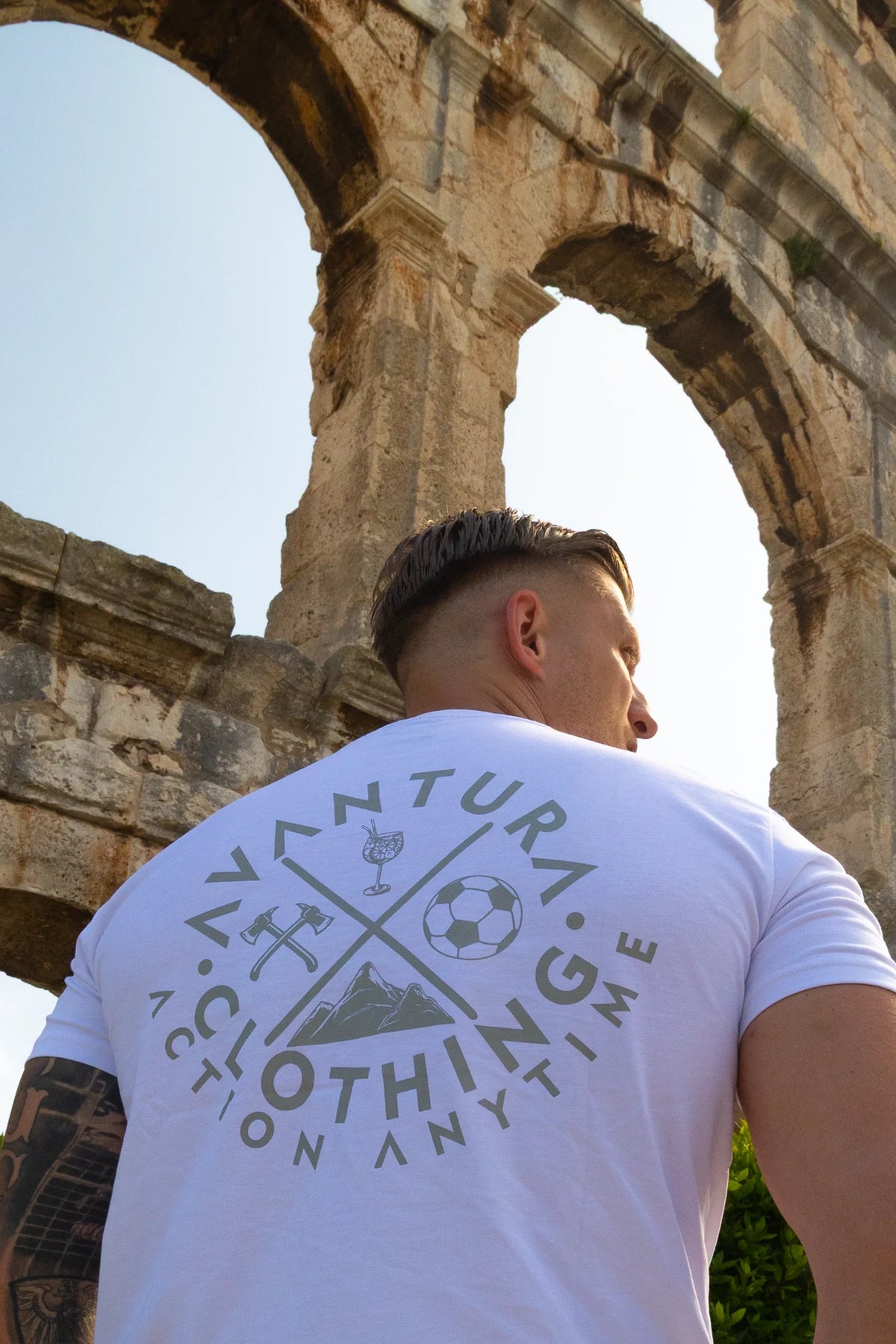White Avantura t-shirt with large circular back print featuring icons and 'Action Anytime' text