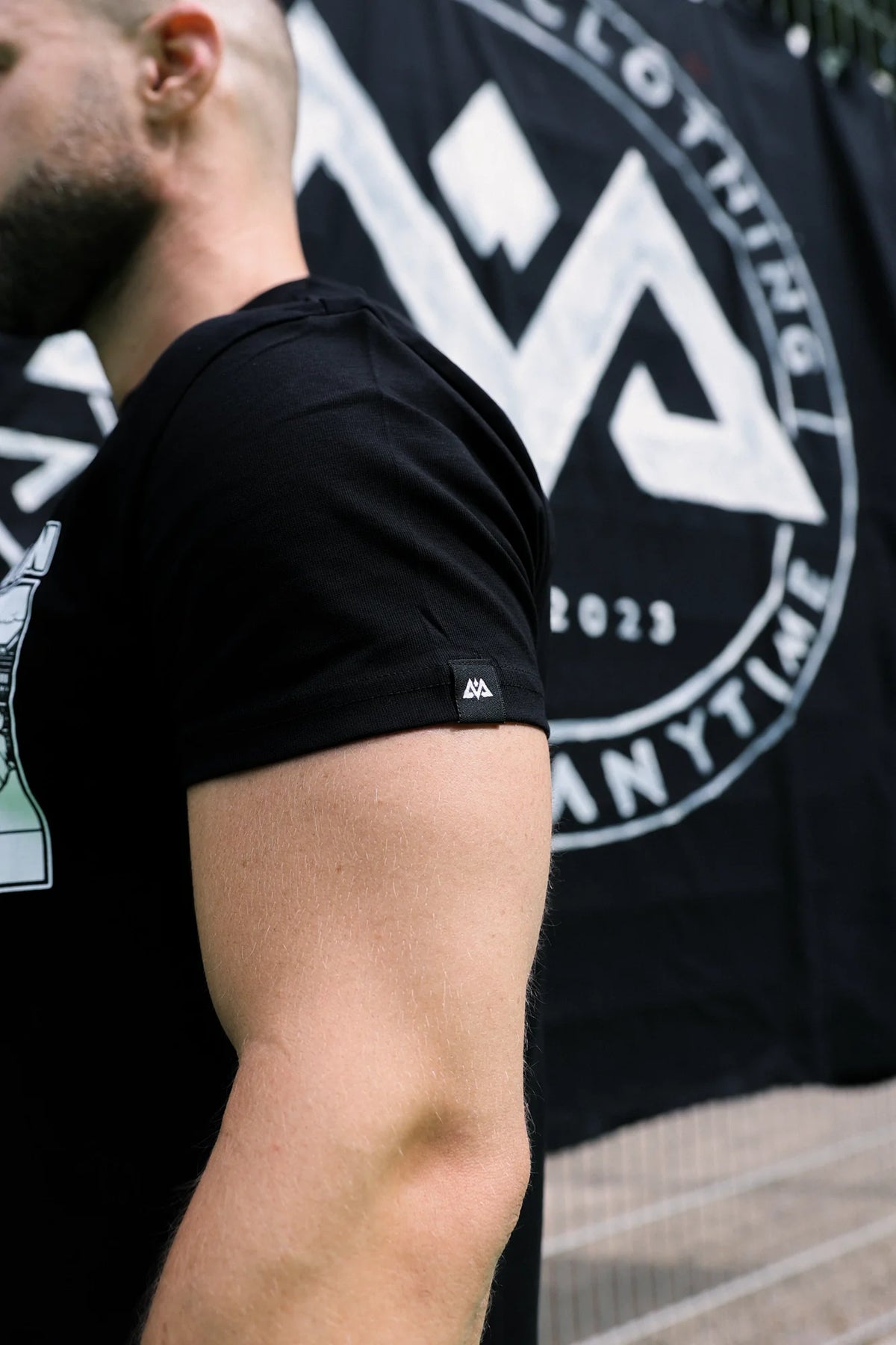 Woven logo label on the sleeve of the black T-shirt