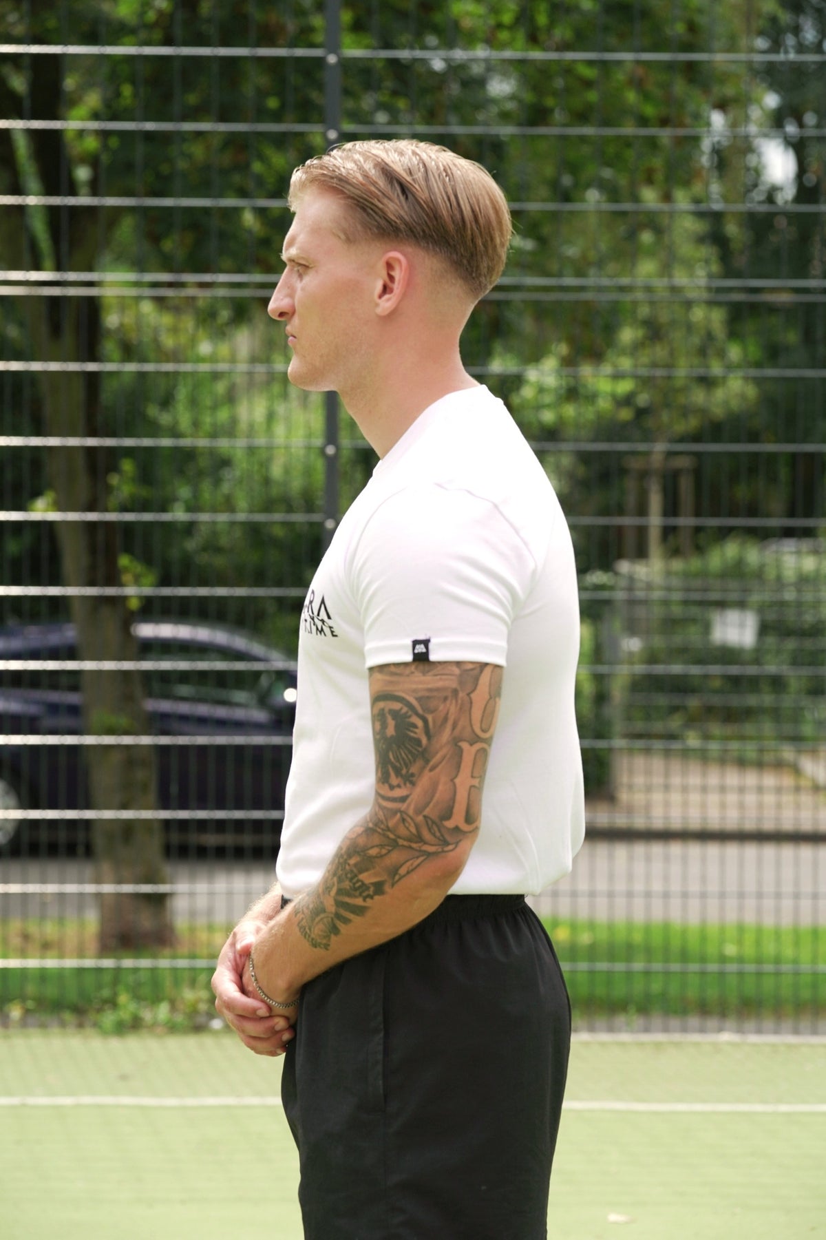 White T-shirt side profile featuring woven sleeve label detail