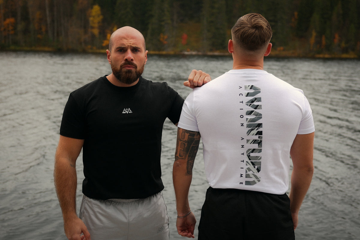Men wearing black and white Avantura T-shirts near lake