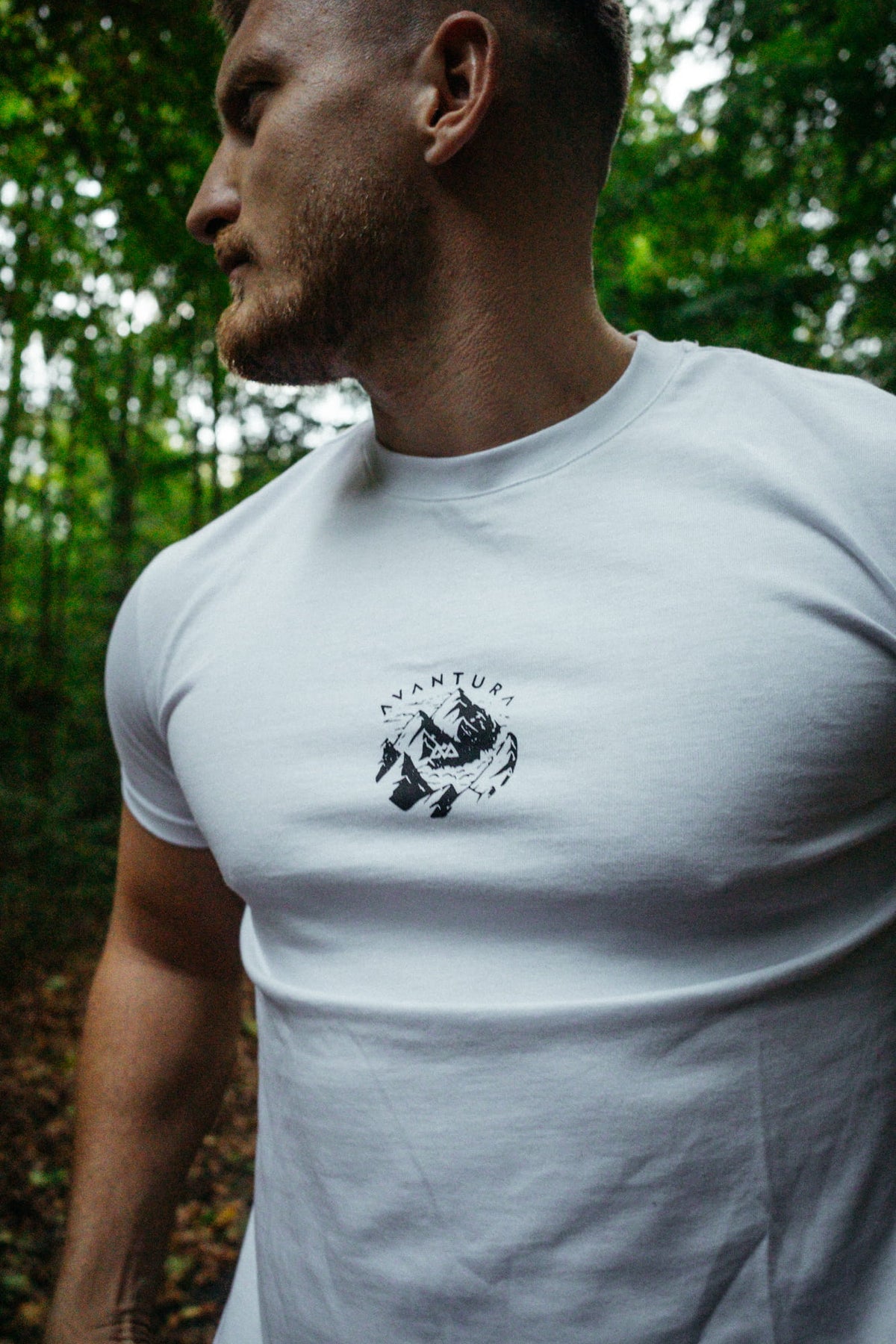 Nahaufnahme des kreisförmigen Berg-Logos auf der Vorderseite des weißen T-Shirts